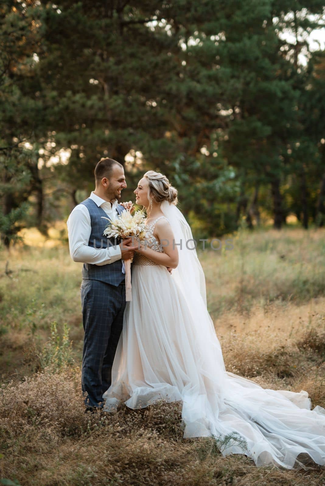 the groom and the bride are walking in the forest on a bright day