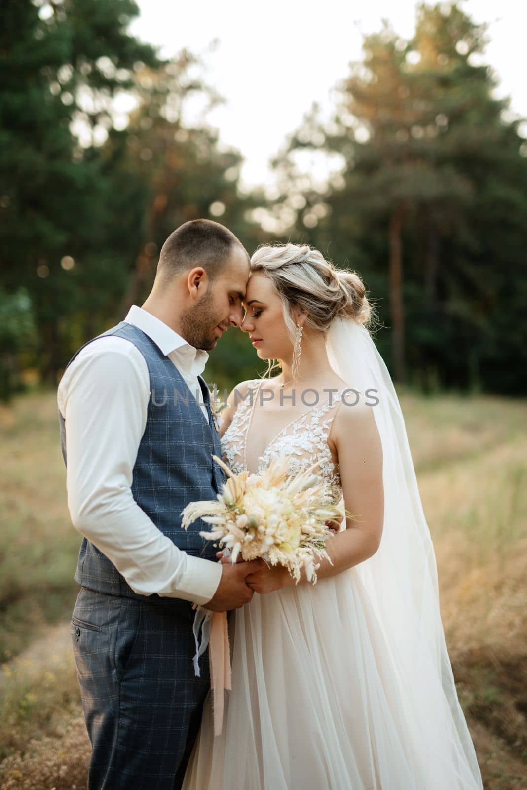 the groom and the bride are walking in the forest on a bright day