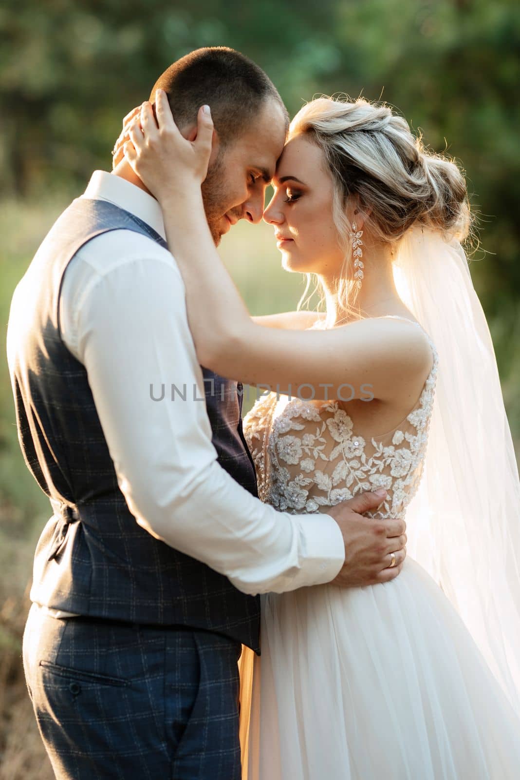 the groom and the bride are walking in the forest on a bright day