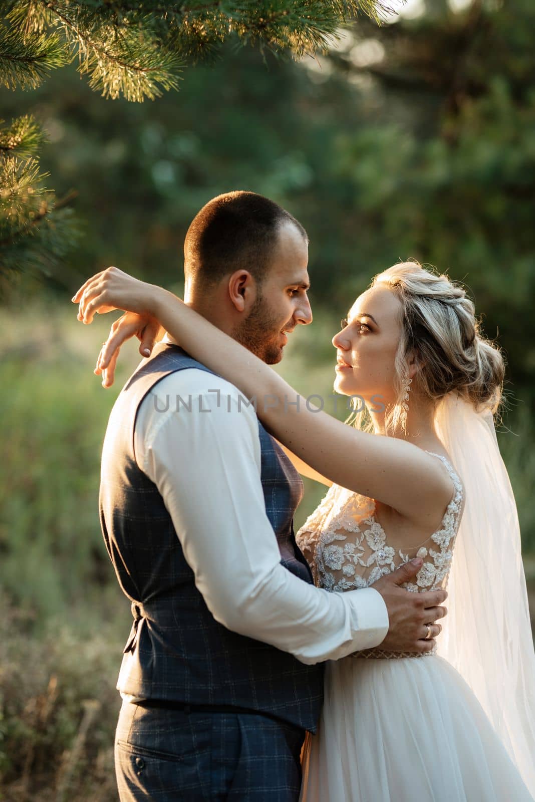 the groom and the bride are walking in the forest on a bright day