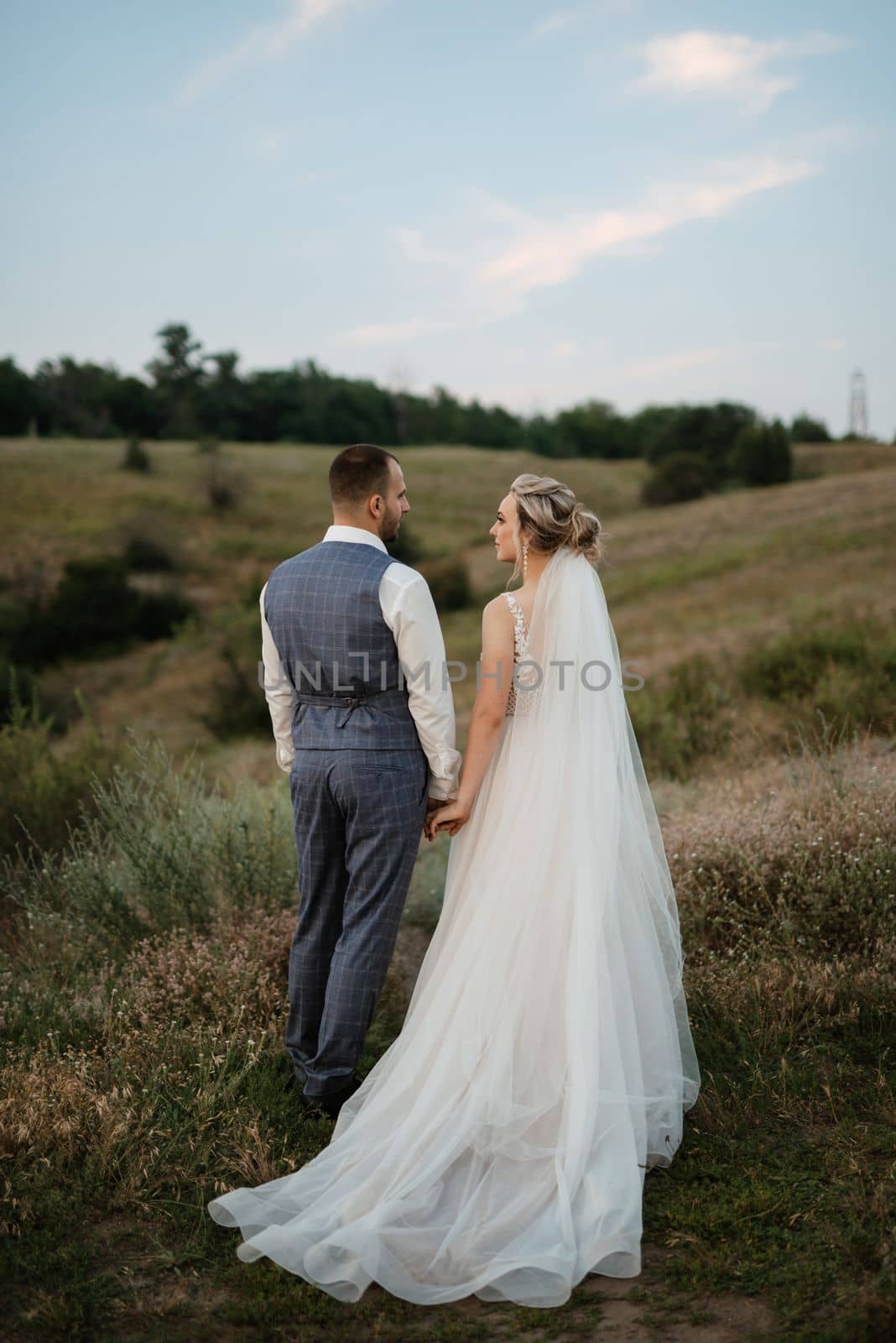 bride blonde girl and groom in a field at sunset light