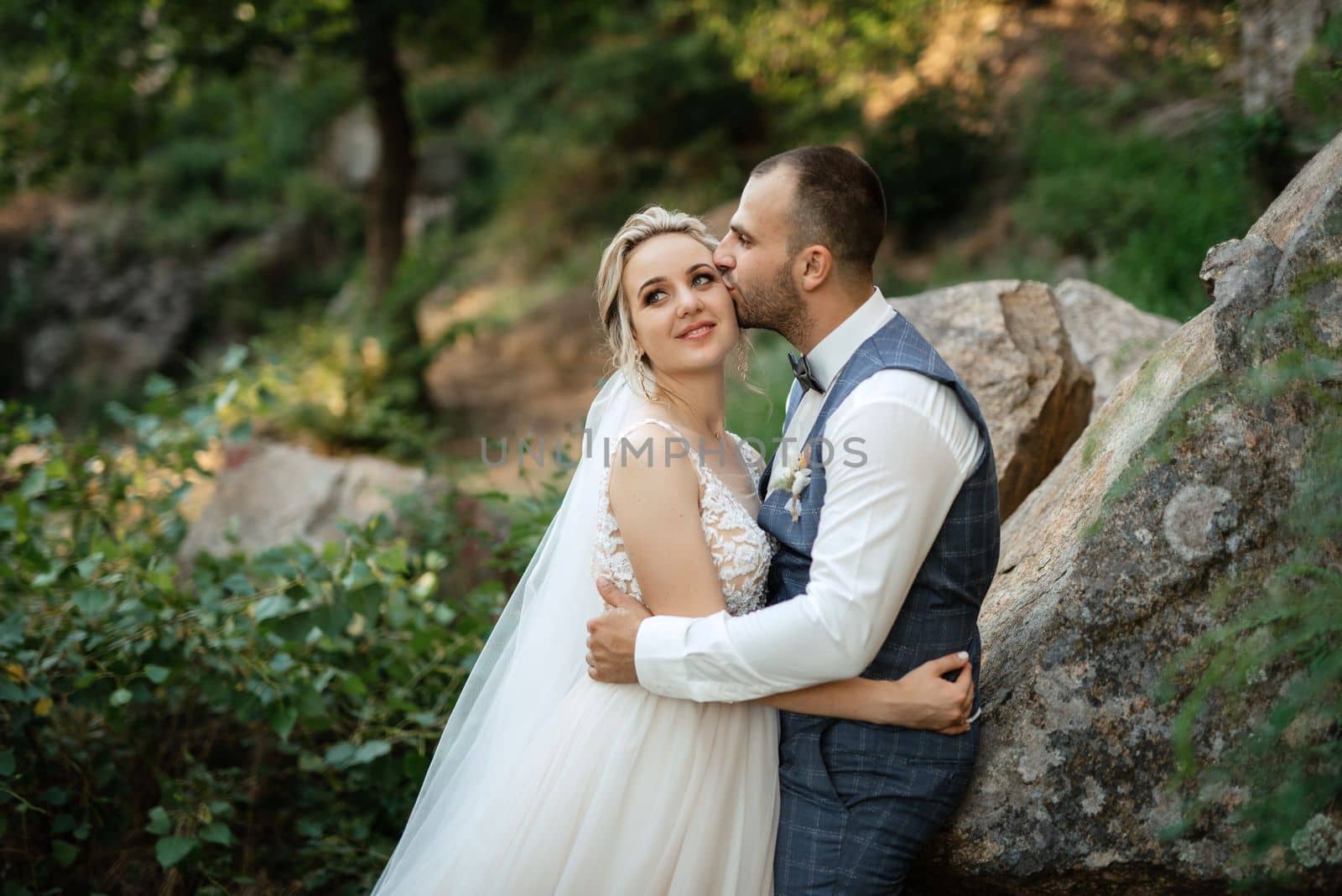 the groom and the bride are walking in the forest on a bright day