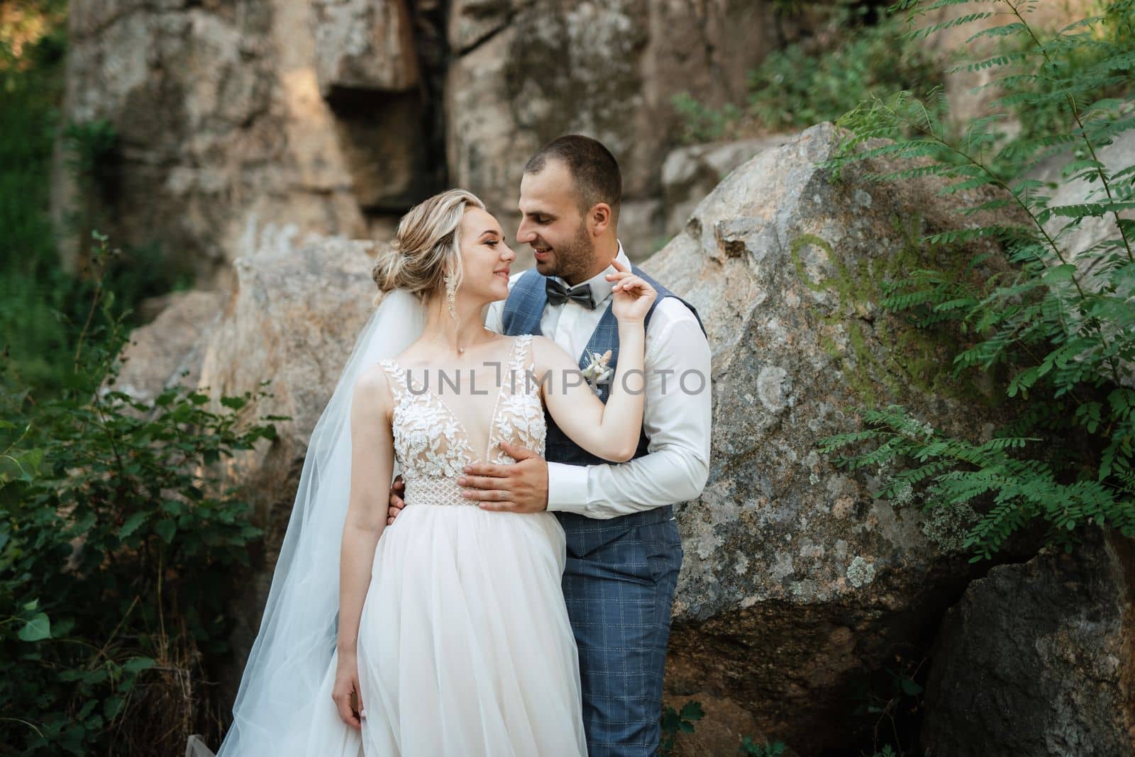 the groom and the bride are walking in the forest on a bright day