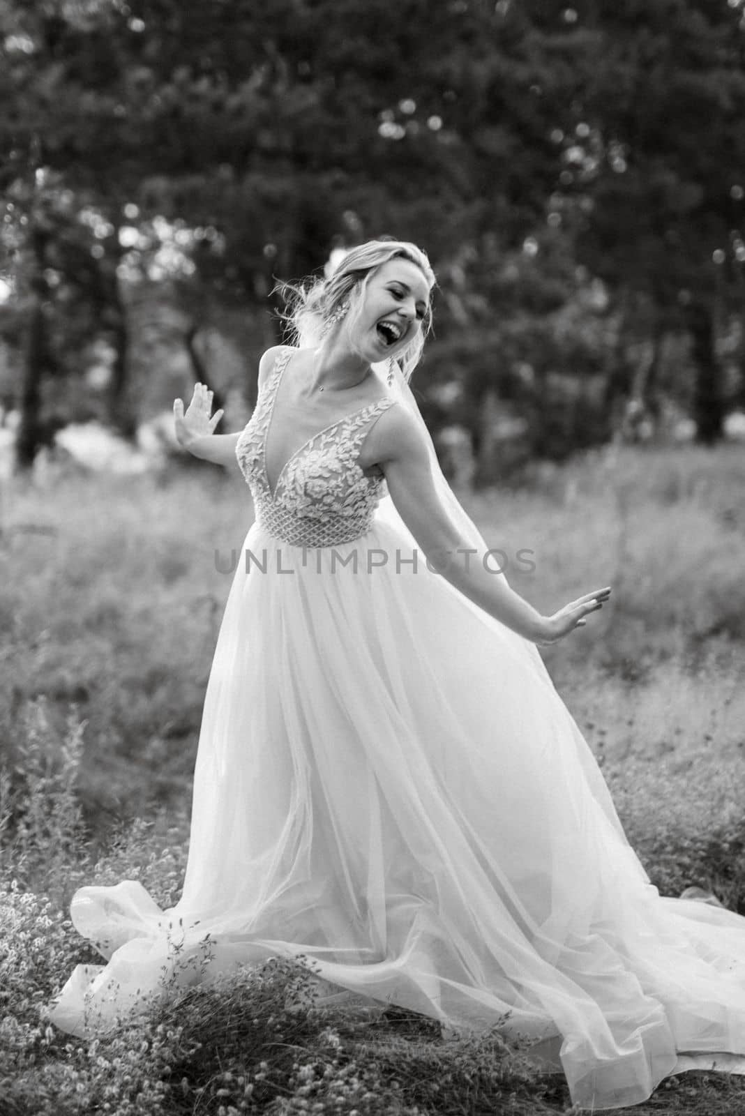 bride blonde girl with a bouquet in the forest in the sunset light