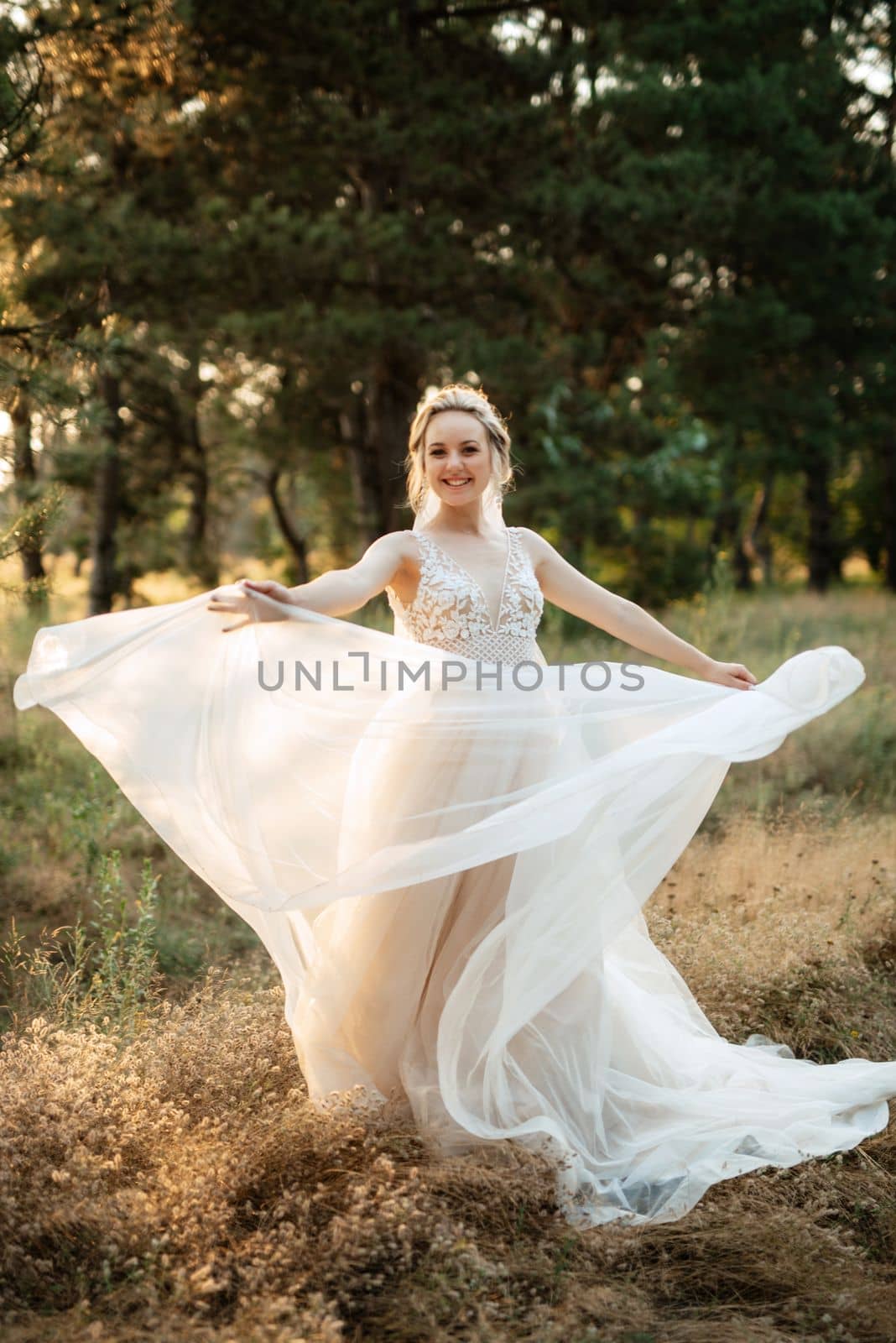 bride blonde girl with a bouquet in the forest in the sunset light