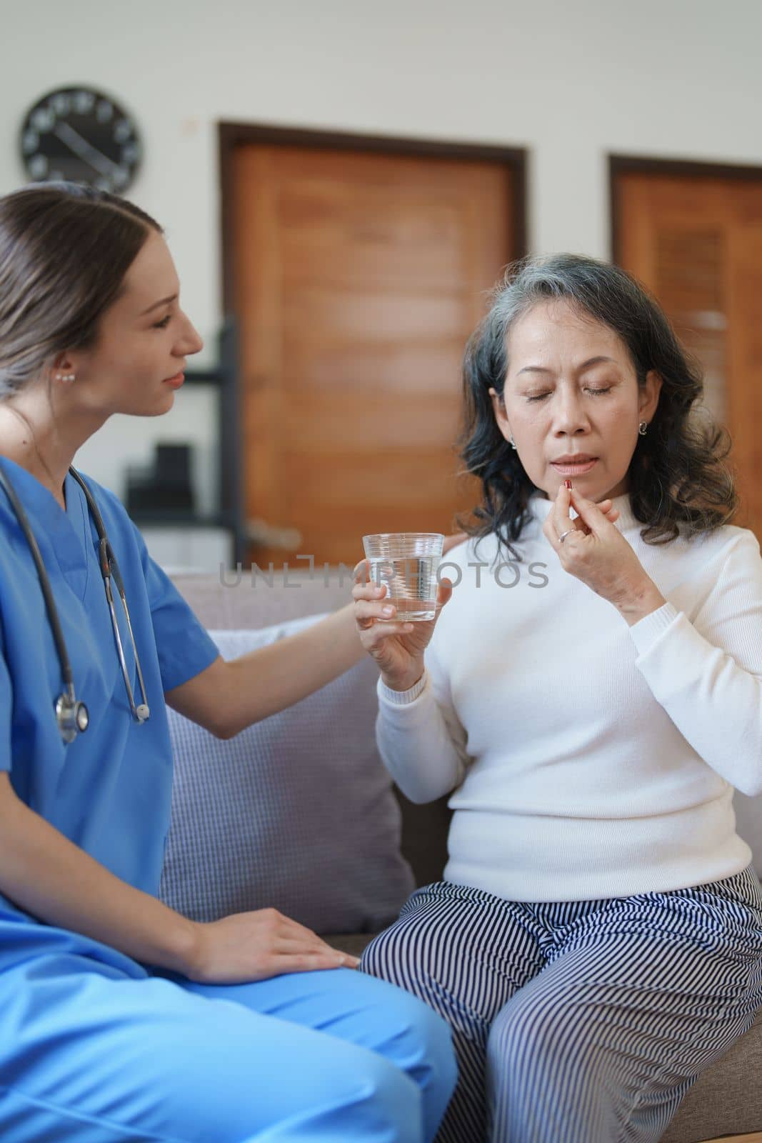 Portrait of a female doctor giving medicine to an elderly patient