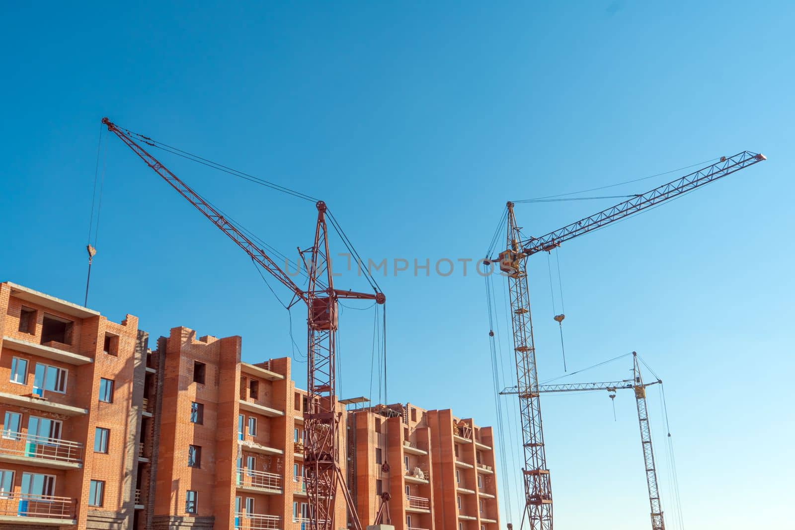 Construction site with a crane.Long-term construction.A new building under construction,bottom-up view.Unfinished skyscraper,frozen construction.Unfinished construction of a multi-storey residential by YevgeniySam