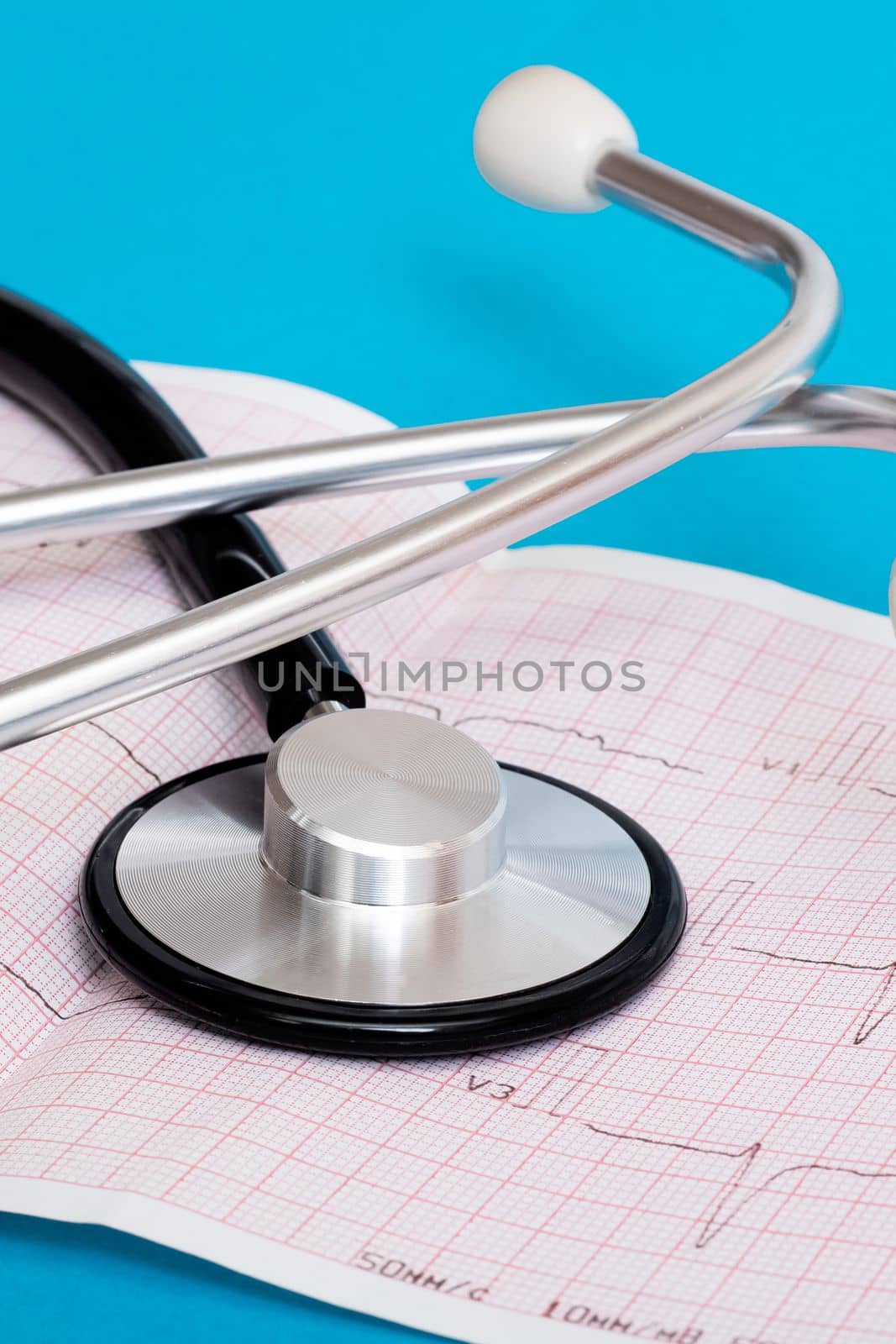 Stethoscope and cardiogram results on a blue background close up