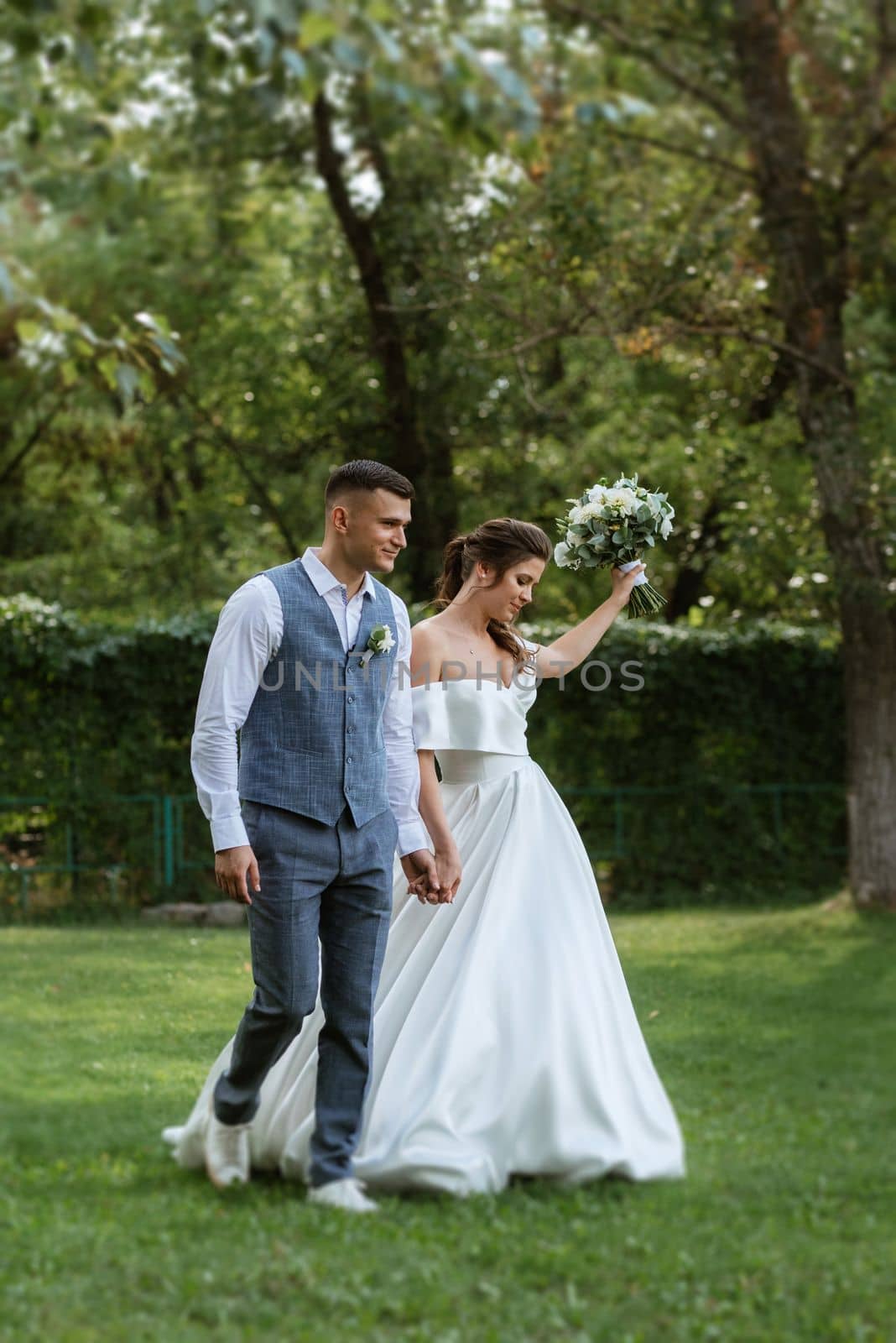 the first meeting of the bride and groom in wedding outfits in the park