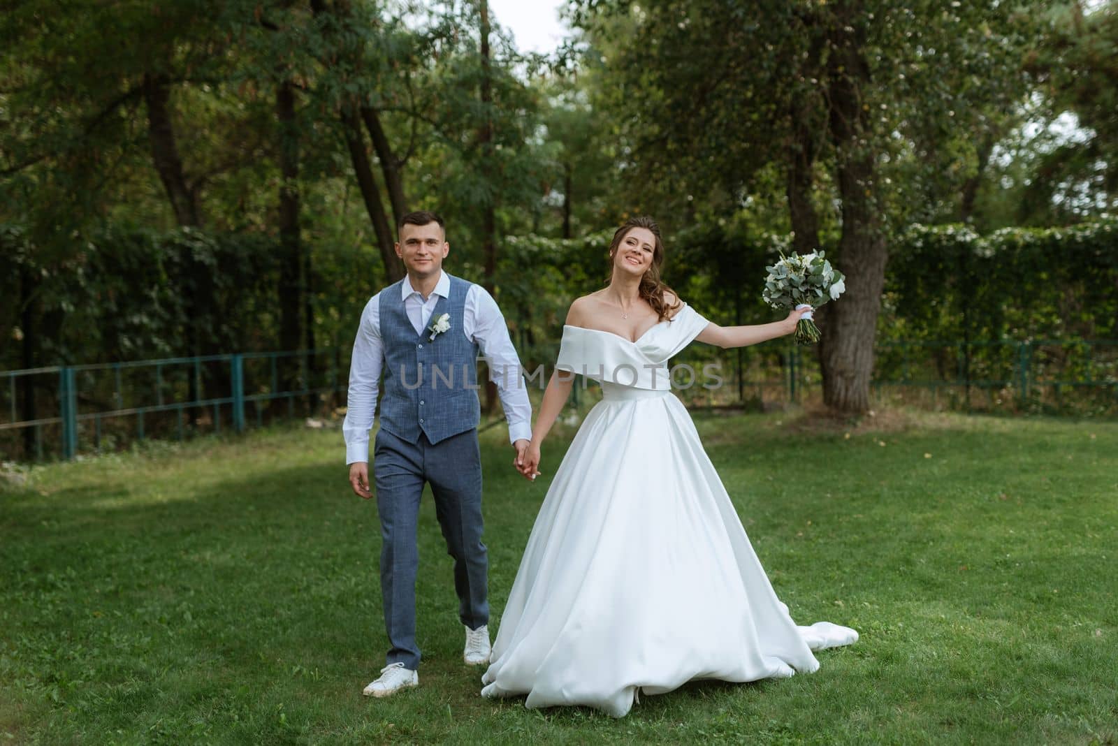 the first meeting of the bride and groom in wedding outfits in the park