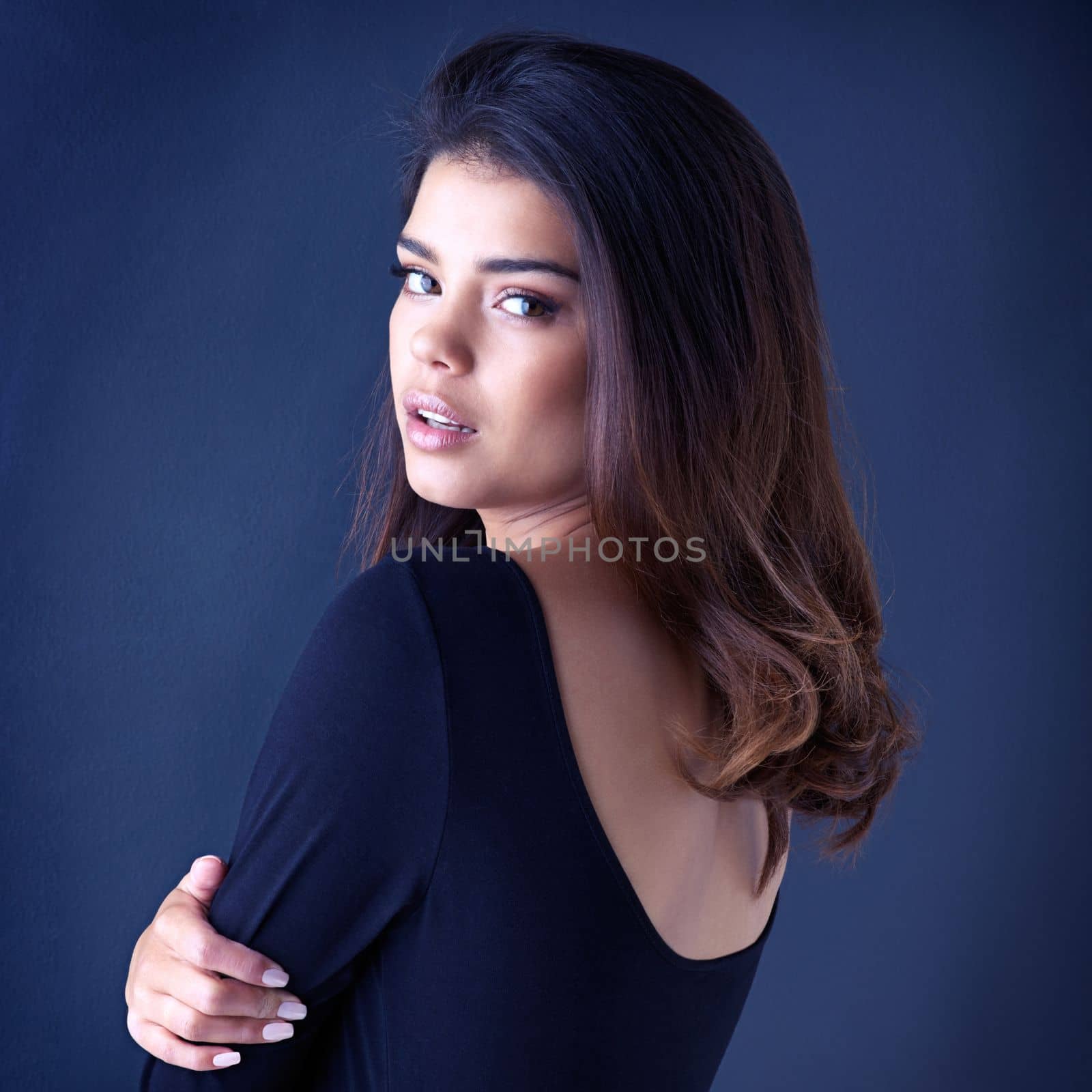 Beauty is in the hands of your stylist. Studio shot of a beautiful young woman posing in the studio