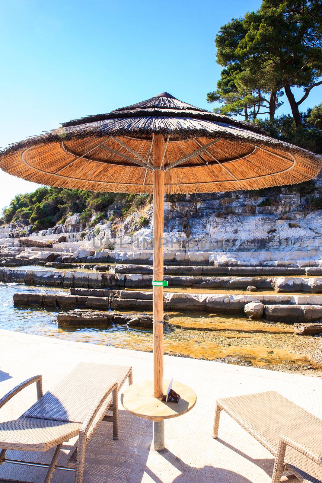 Beach umbrellas in Saint Nicholas island in Porec, Istria. Croatia