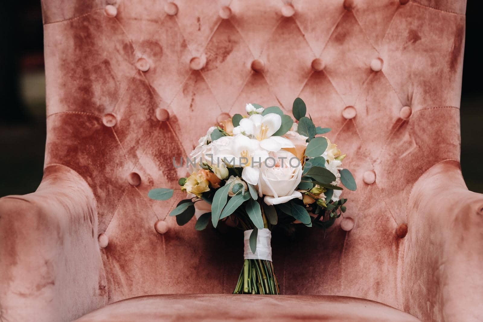 wedding bouquet with roses on the table and a boutonniere.The decor at the wedding.