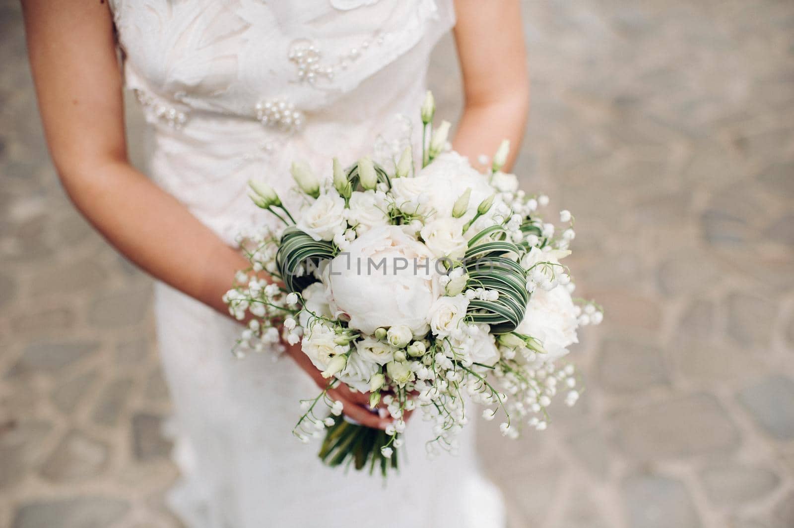 wedding bouquet with peonies in the hands of the bride under the veil.Morning of the bride.