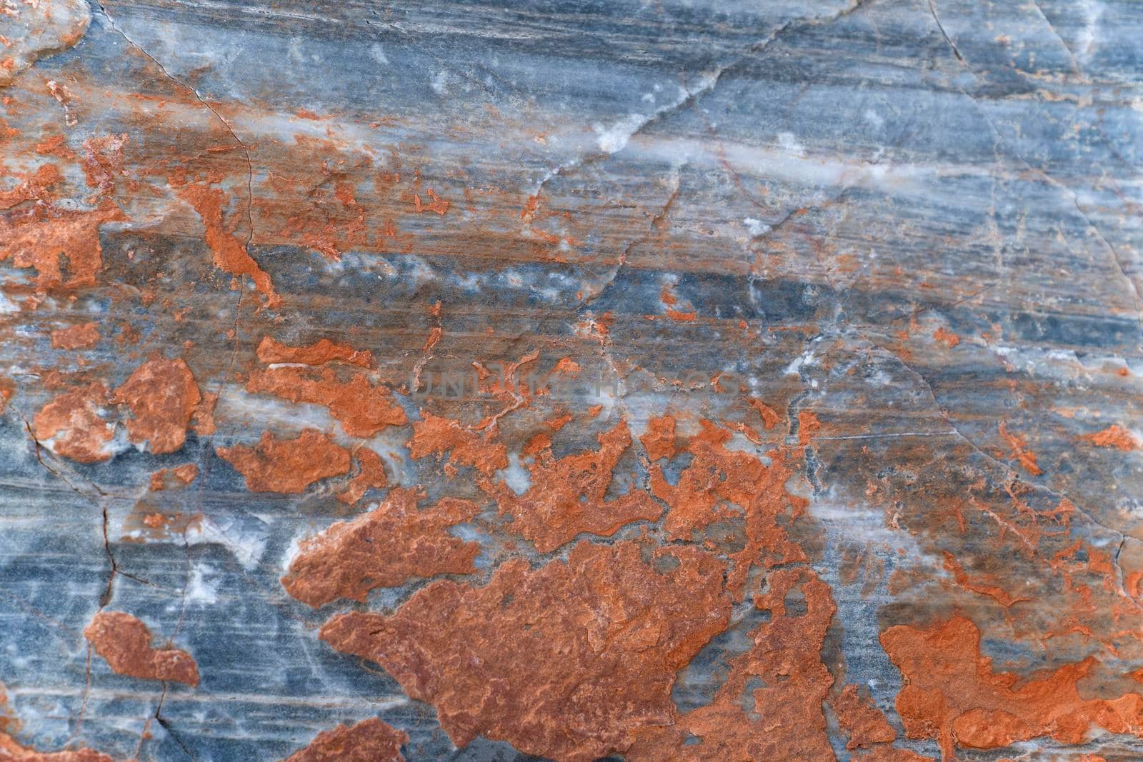 Orange rust coating on gray surface of stone. Background, texture.