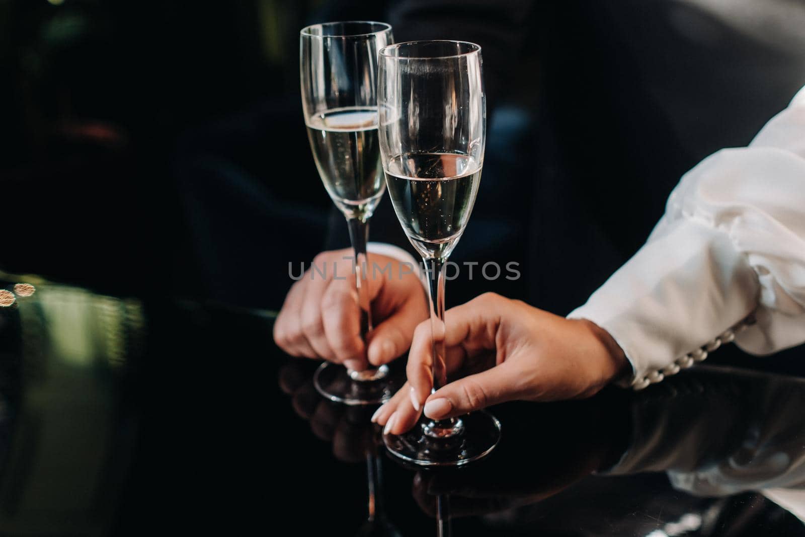 A man and a woman hold champagne glasses in their hands close-up.