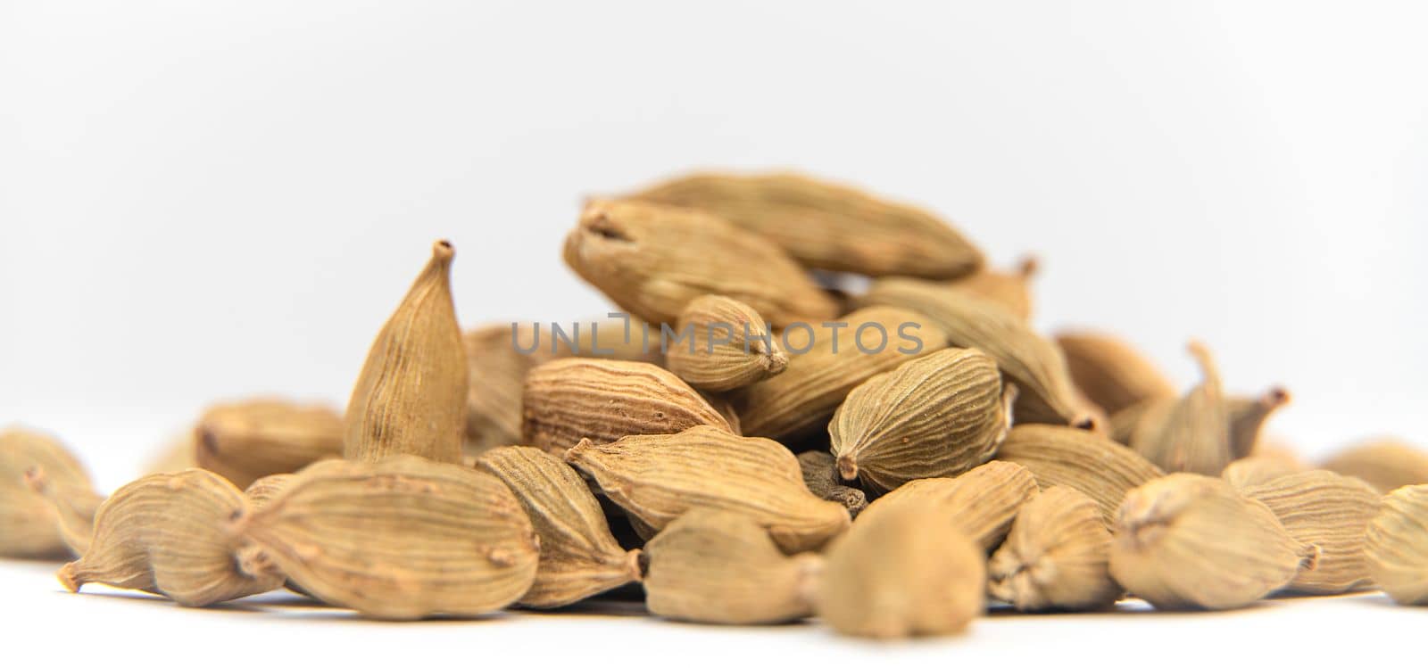Cardamon seeds on a white background.