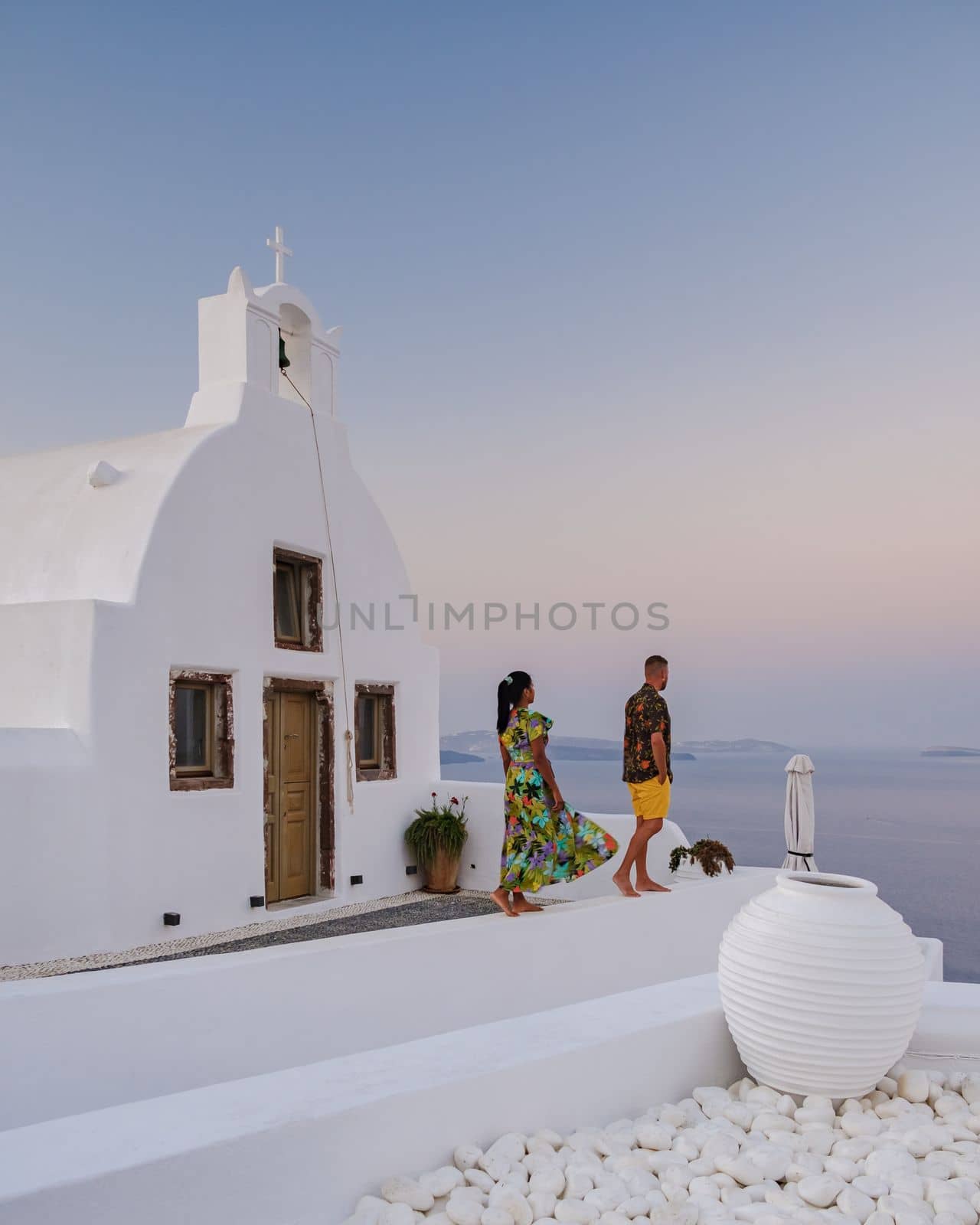 A couple walking at the village of Oia Santorini Greece, men and women visit the whitewashed Greek village of Oia during summer vacation