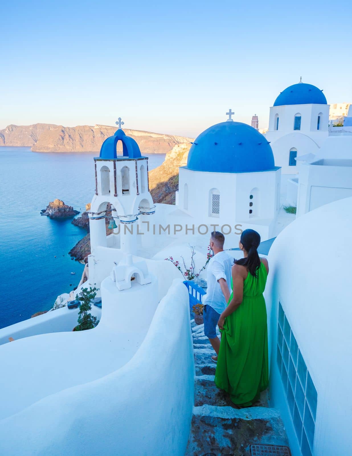 A couple walking at the village of Oia Santorini Greece, men and women visit the whitewashed Greek village of Oia during summer vacation