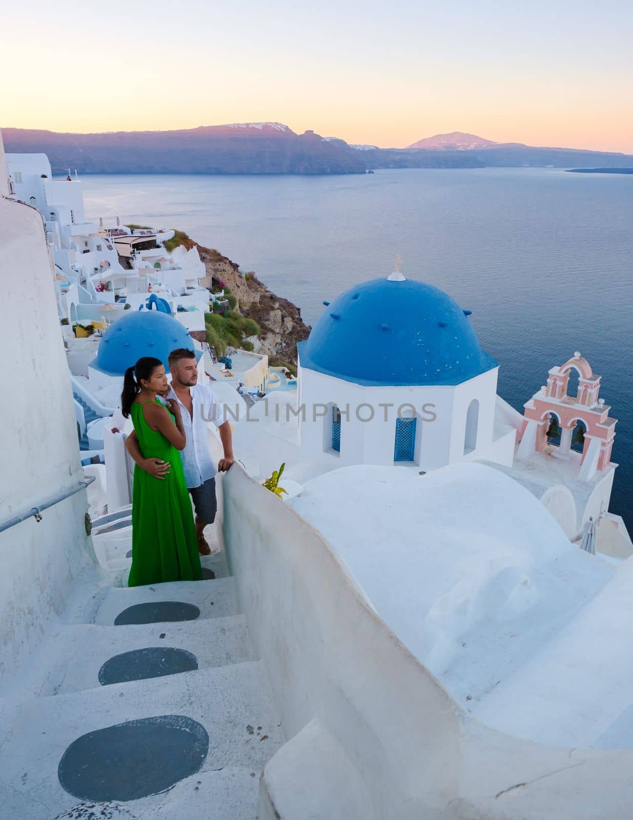Couple on vacation in Santorini Greece, men and women visit the whitewashed Greek village of Oia during summer vacation on a sunny day