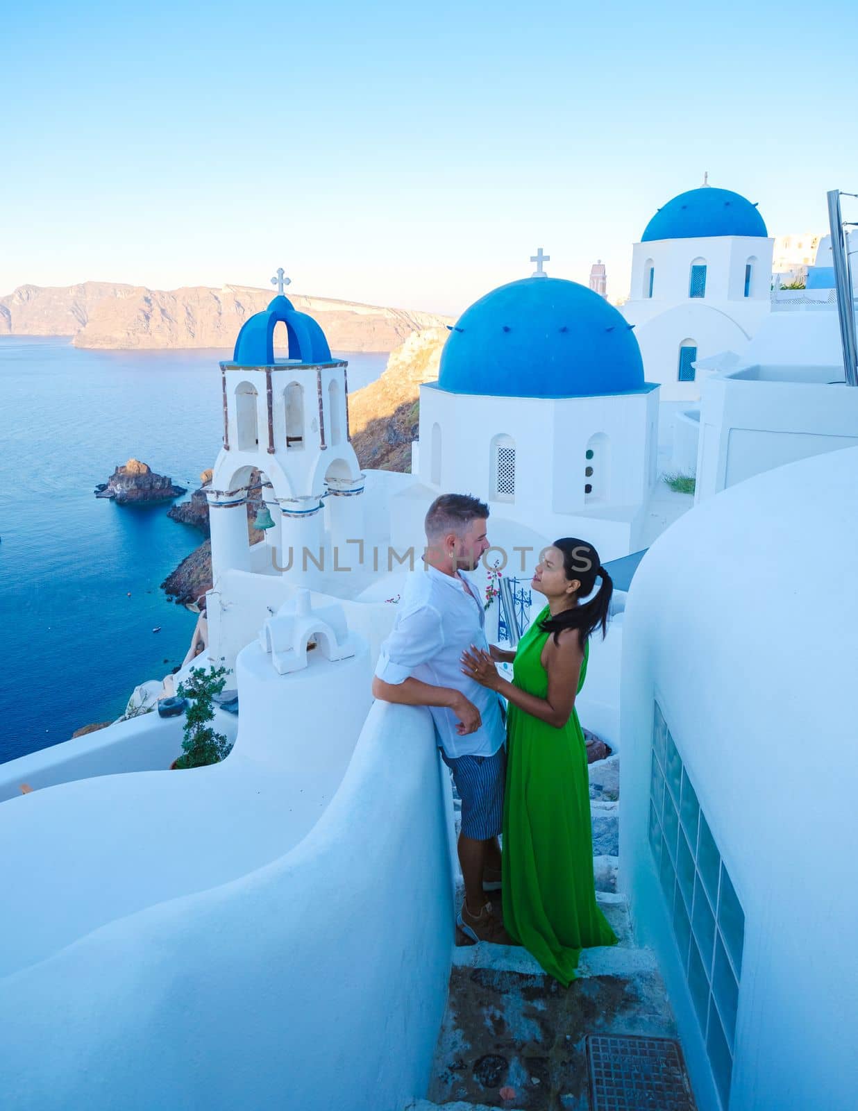 Couple on vacation in Santorini Greece, men and women visit the whitewashed Greek village of Oia during summer vacation