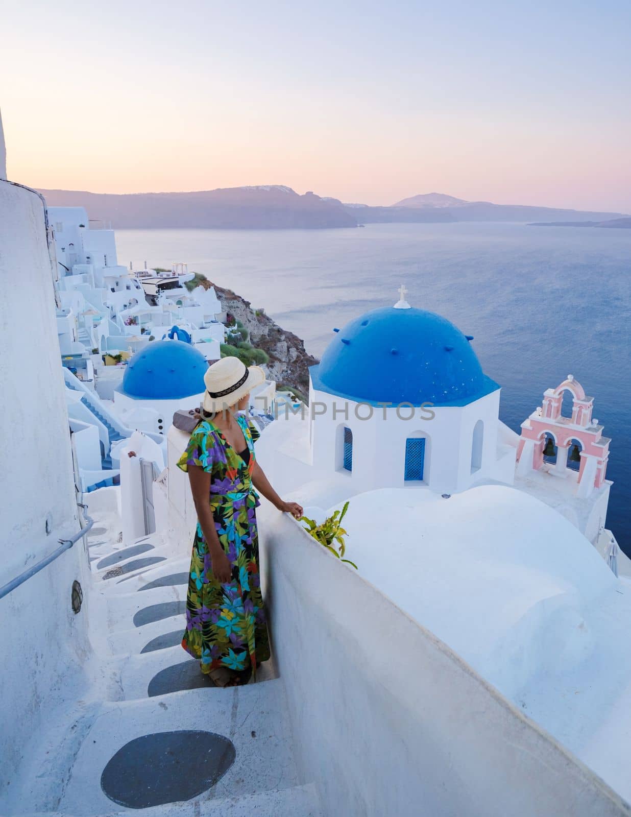 Young Asian women on vacation in Santorini Greece, girl with hat at the Greek village in Santorini by fokkebok