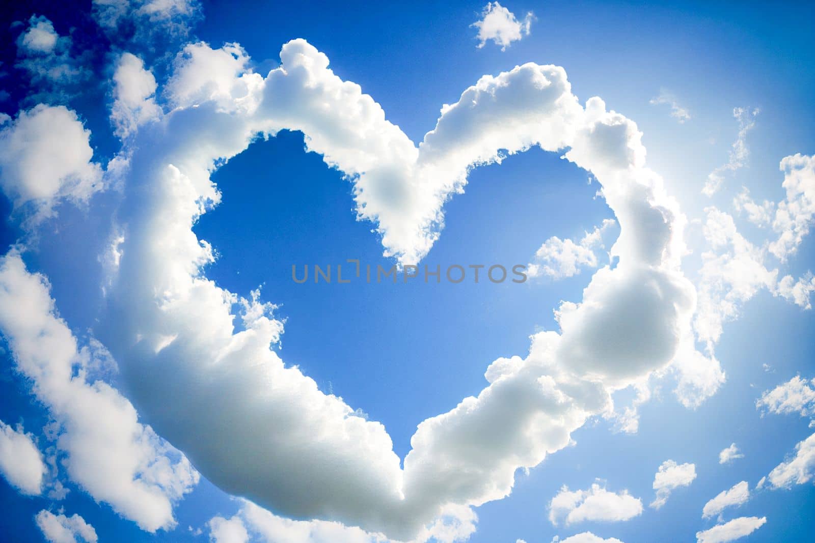 Heart shaped cloud on bright blue sky and white clouds.