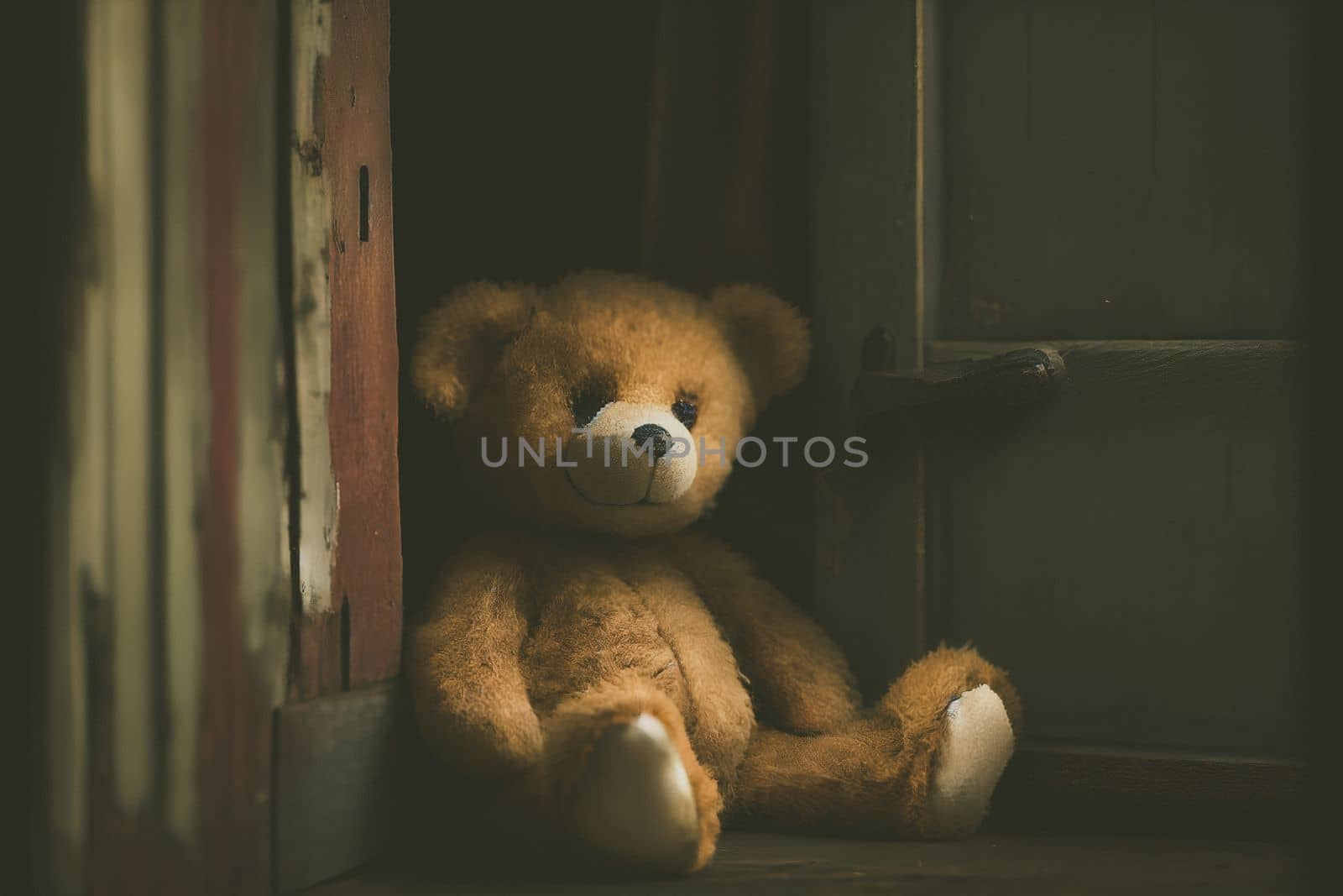 Small brown teddy bear sitting alone in an old, abandoned house, evoking feelings of loneliness and neglect concept.