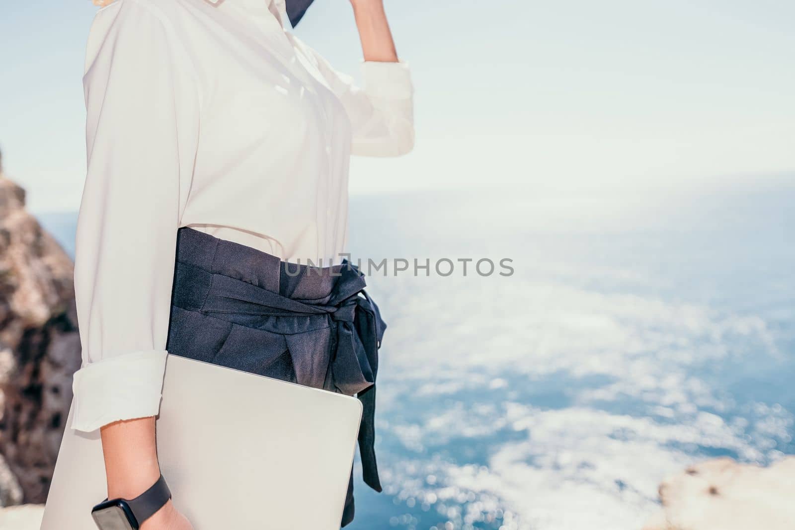 Woman sea laptop. Business woman in yellow hat freelancer with laptop working over blue sea beach. Girl relieves stress from work. Freelance, digital nomad, travel and holidays concept by panophotograph