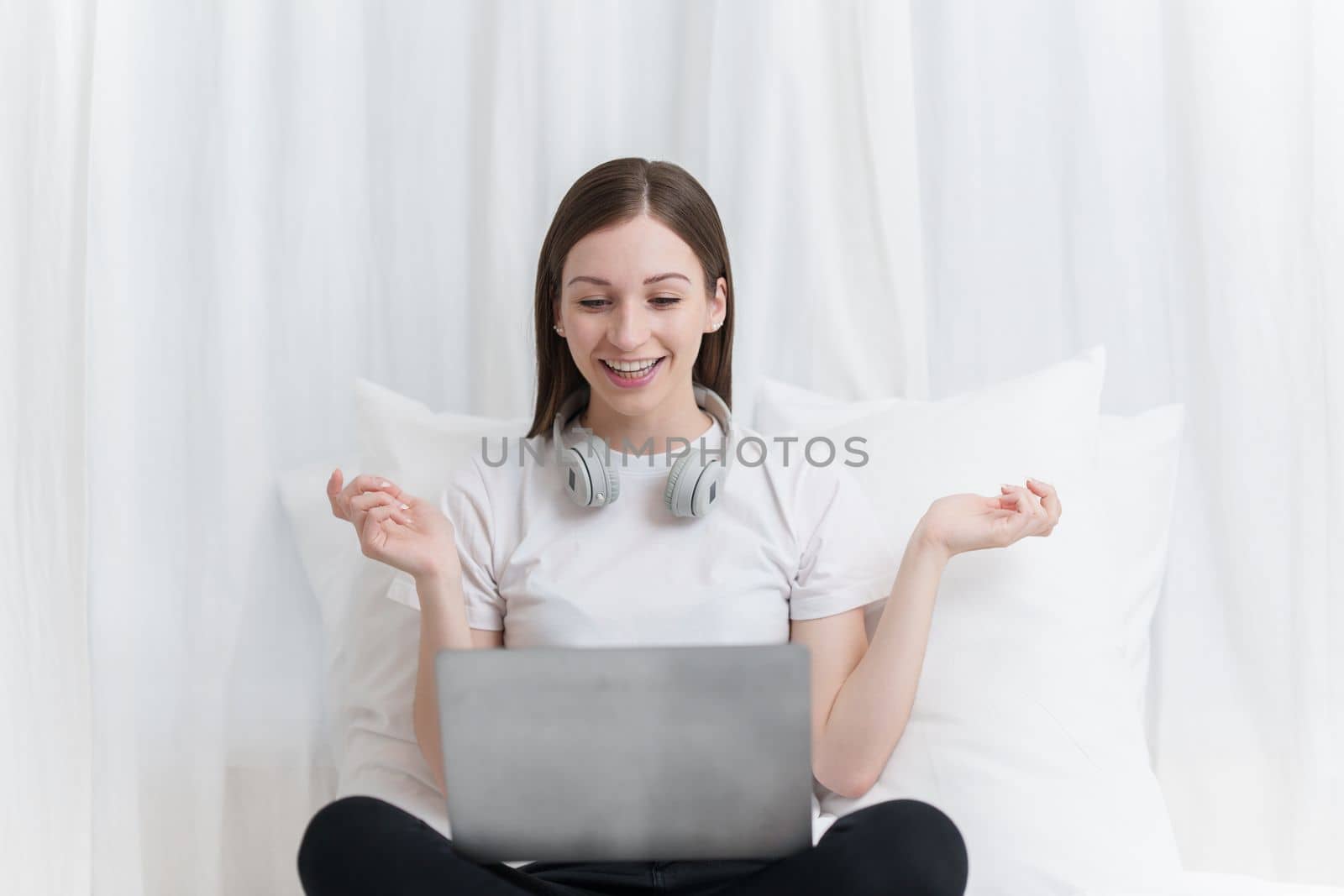 Image of beautiful young woman resting and watching movie in bed at bedroom. Lifestyle at home concept.