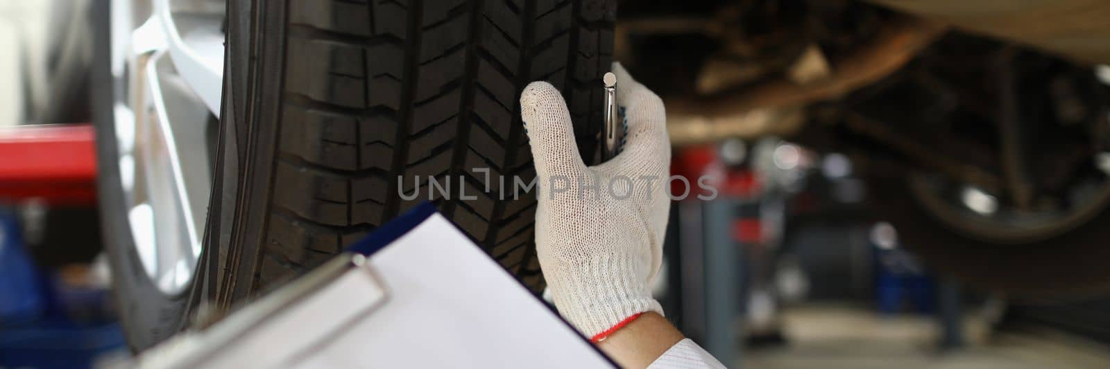 Man mechanic working under car at car service station by kuprevich