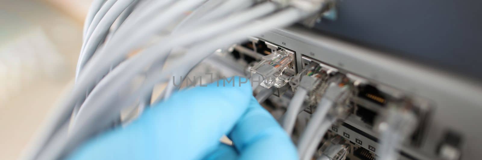 Hand of IT engineer technician with lot of internet network cable in wireless system of server room. Internet via cable from router