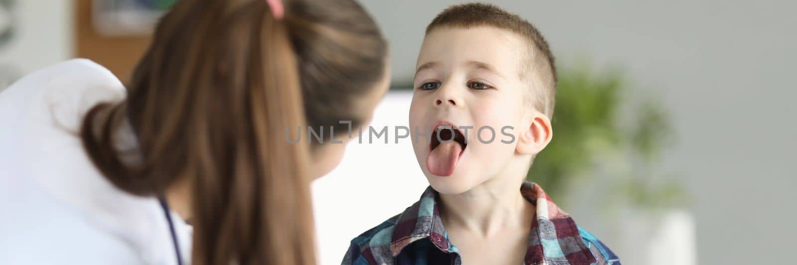 Doctor consults little boy with sore throat. Inflammation of tonsils of adenoids and tonsillitis in children