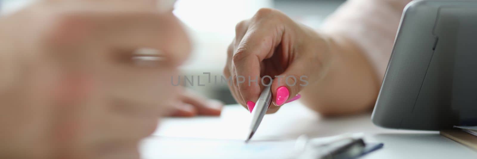 Business people write and discuss documents with tablet computer on table. Signing of insurance documents and contracts
