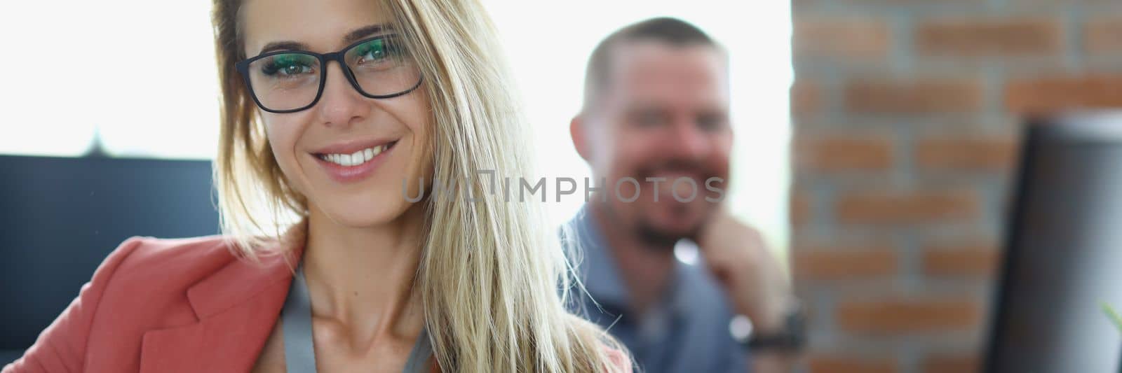 Portrait of happy businesswoman in glasses at workplace in office. Smiling confident young woman manager