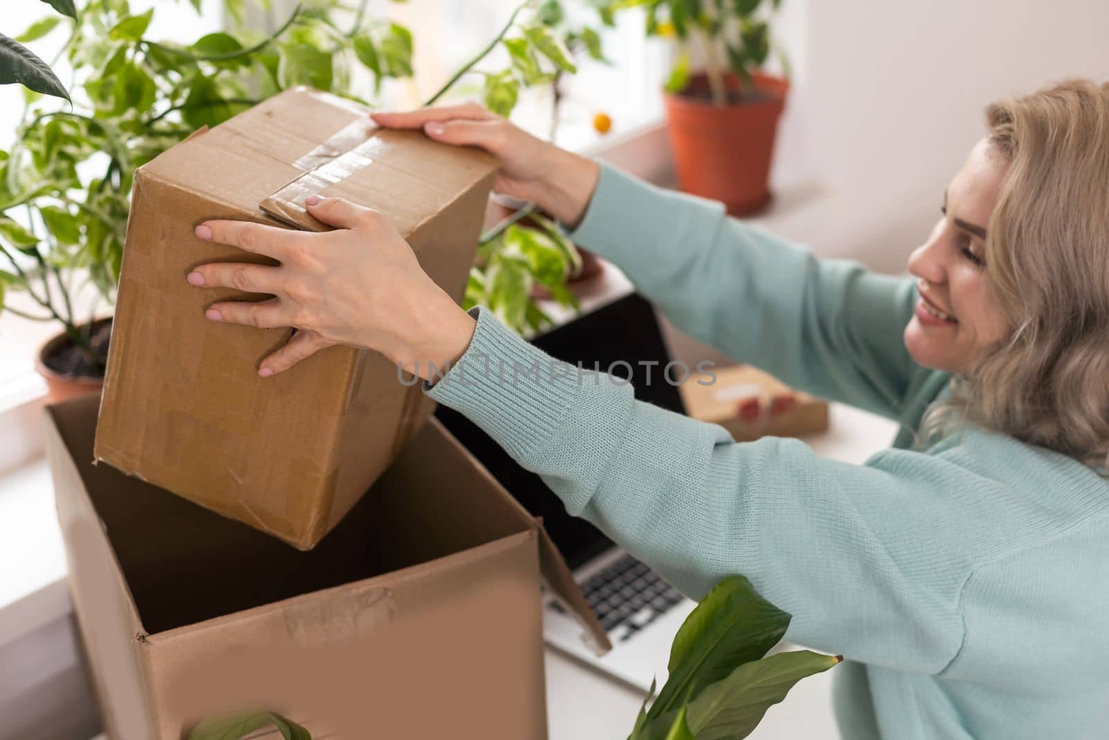 Closeup view of female online store small business owner seller entrepreneur packing package post shipping box preparing delivery parcel on table. Ecommerce dropshipping shipment service concept by Andelov13