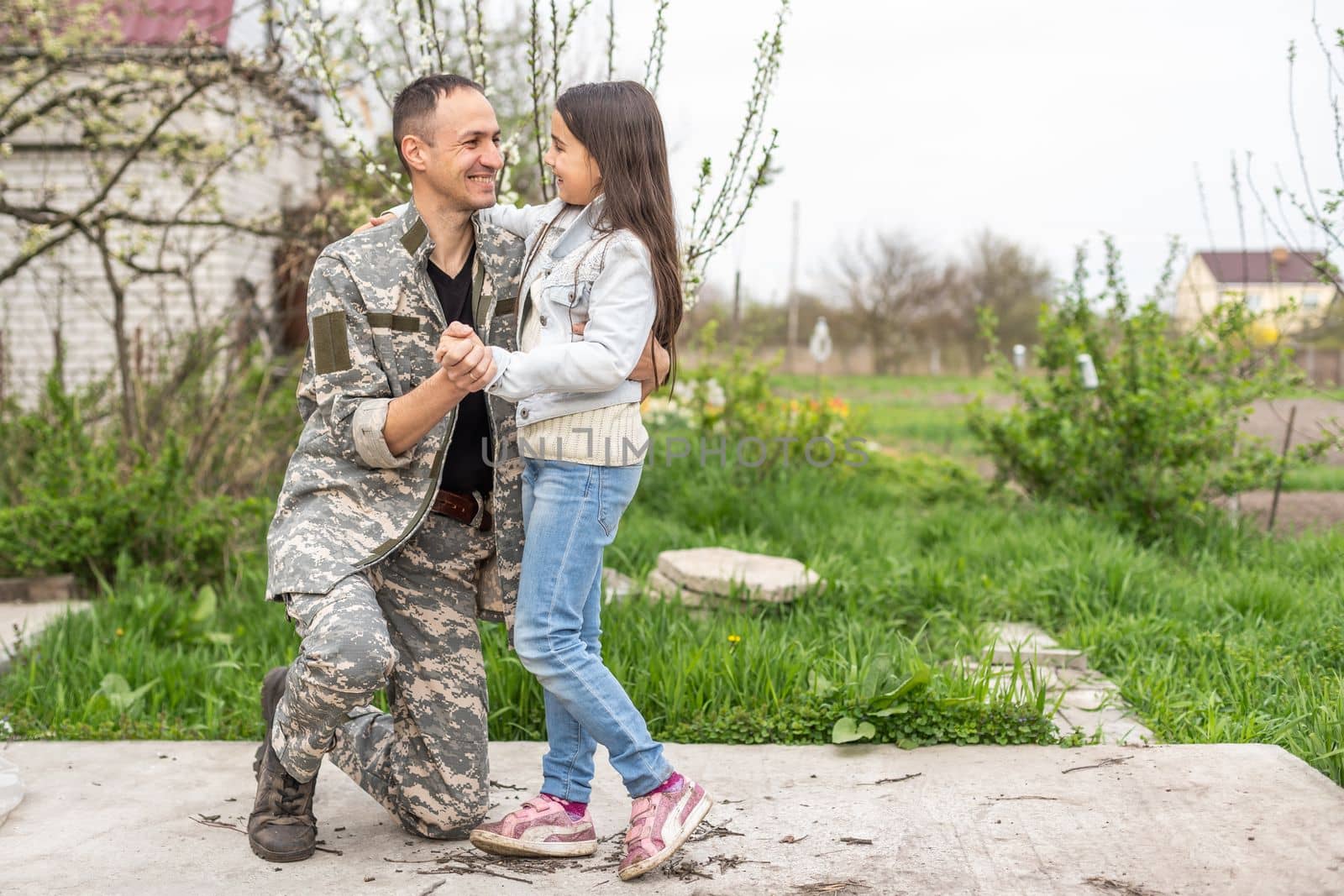 Little child is very happy her father came back from army. Little kid is hugging her father by Andelov13