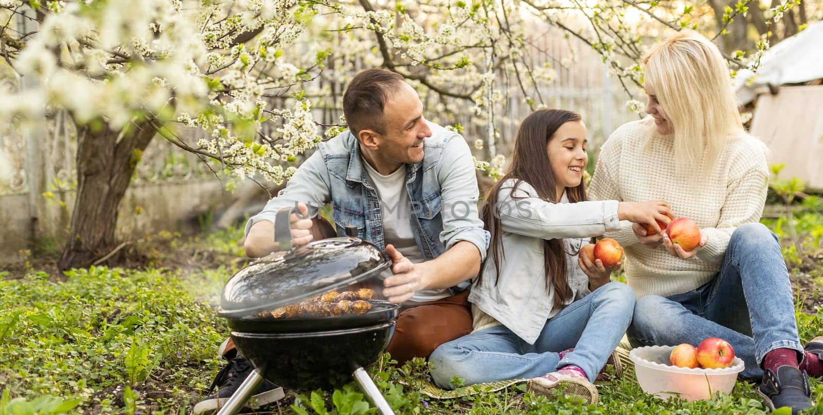 Happy family having barbecue with modern grill outdoors by Andelov13