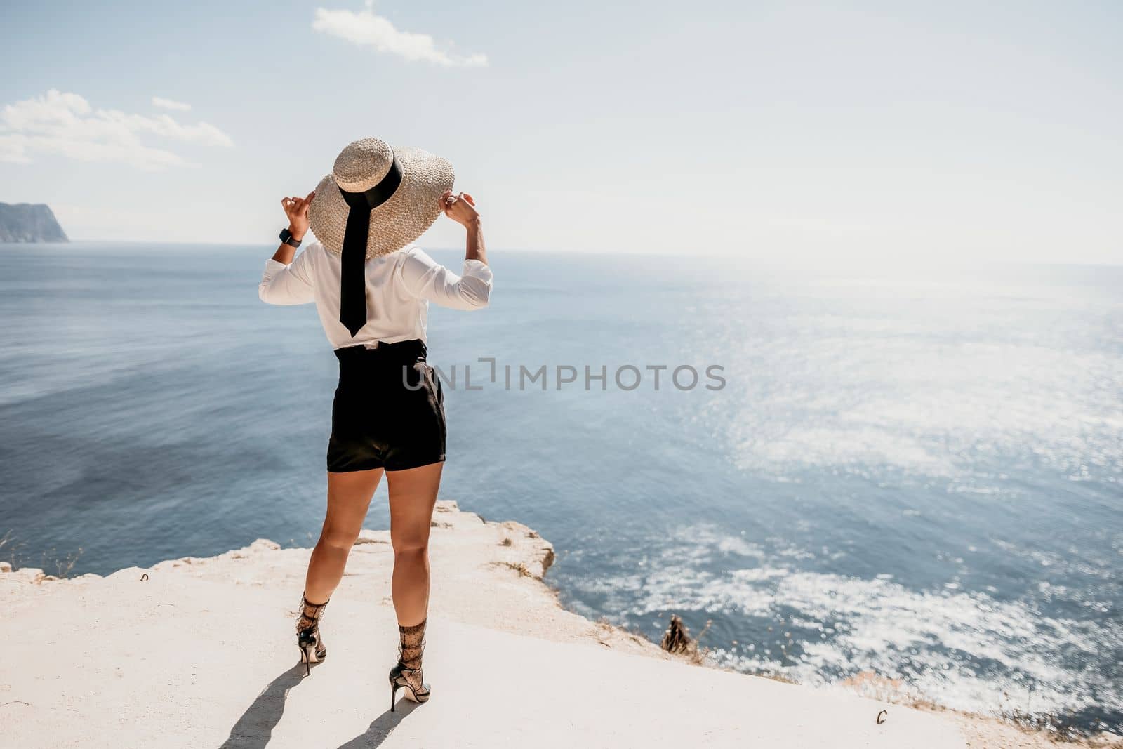 Woman sea hat. Business woman in yellow hat freelancer working over blue sea beach. Girl relieves stress from work. Freelance, digital nomad, travel and holidays concept by panophotograph