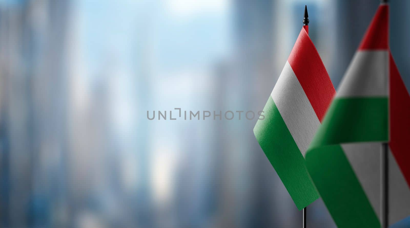 Small flags of the Hungary on an abstract blurry background by butenkow