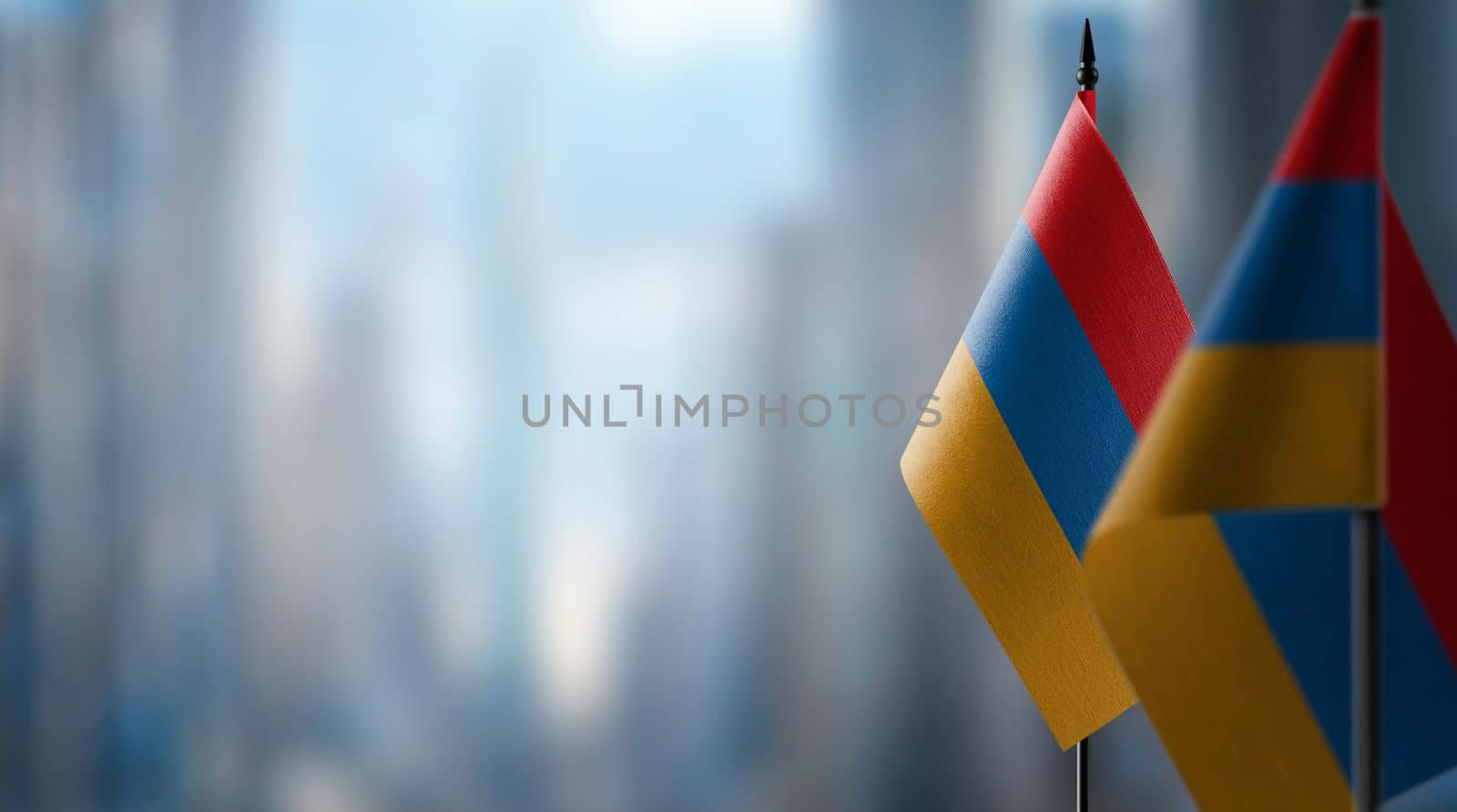 Small flags of the Armenia on an abstract blurry background.