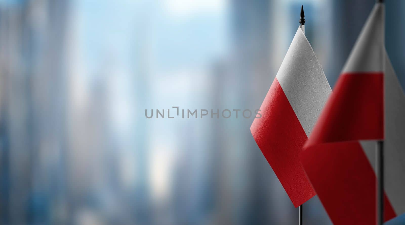Small flags of the Poland on an abstract blurry background by butenkow