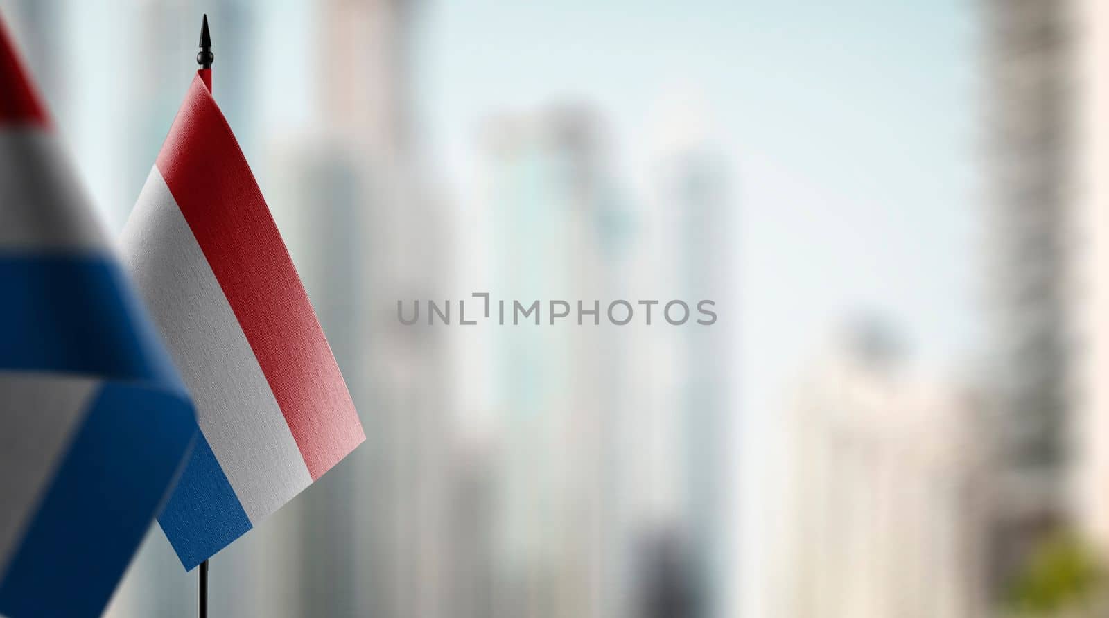 A small Netherlands flag on an abstract blurry background by butenkow