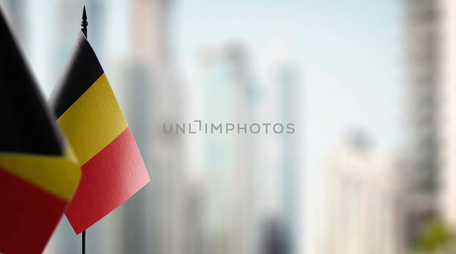 Small flags of the Belgium on an abstract blurry background.