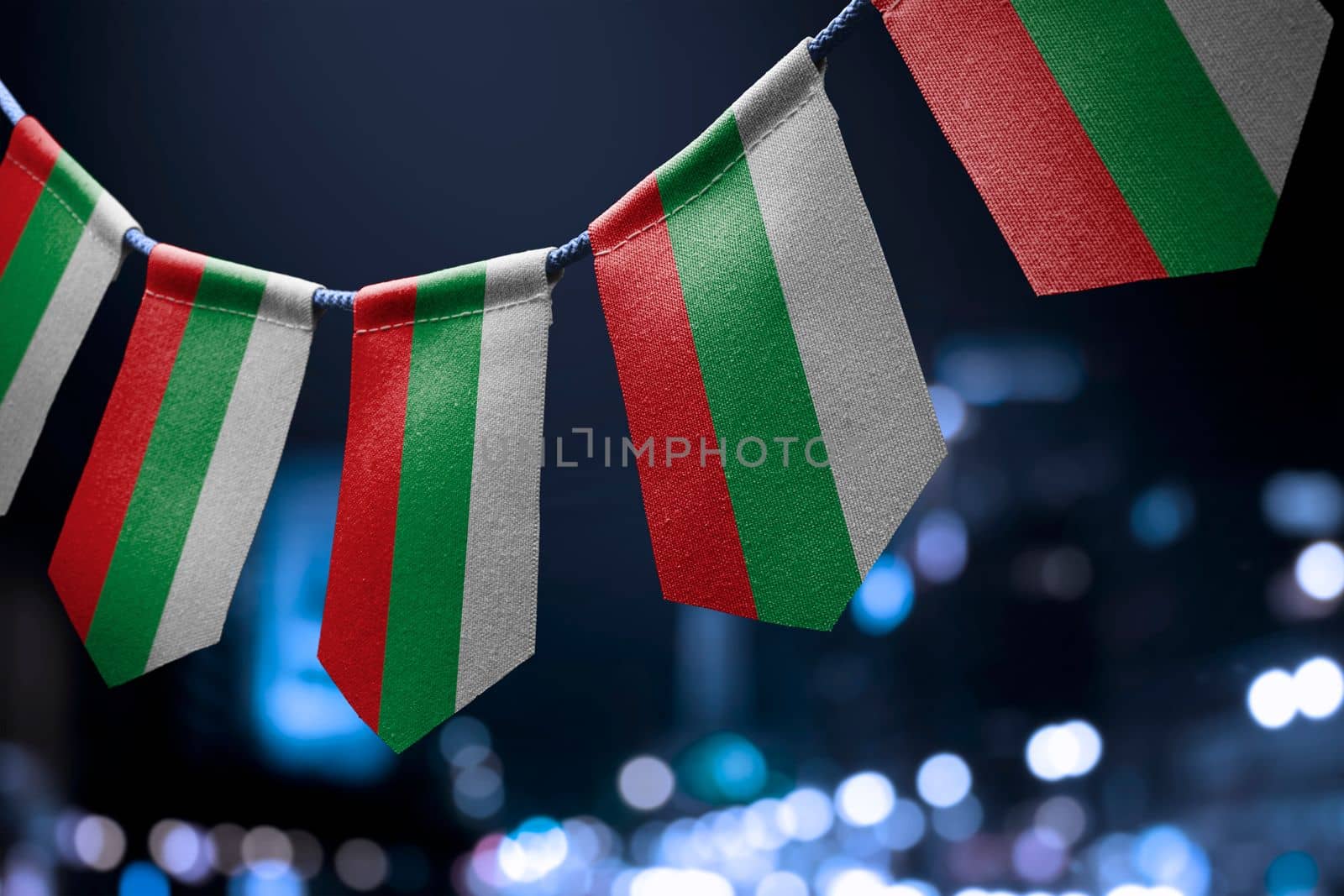 A garland of Bulgaria national flags on an abstract blurred background by butenkow