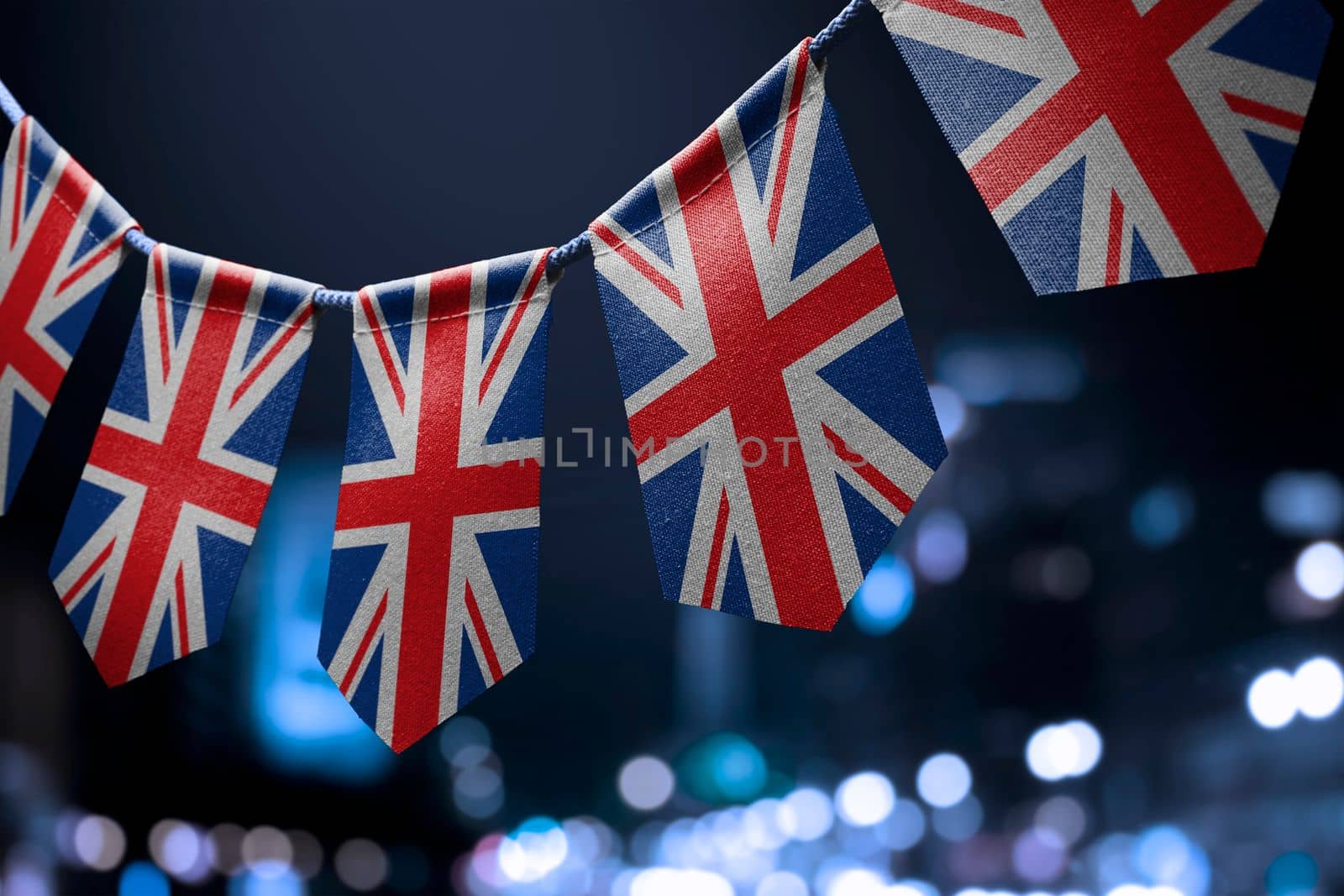 A garland of United Kingdom national flags on an abstract blurred background.