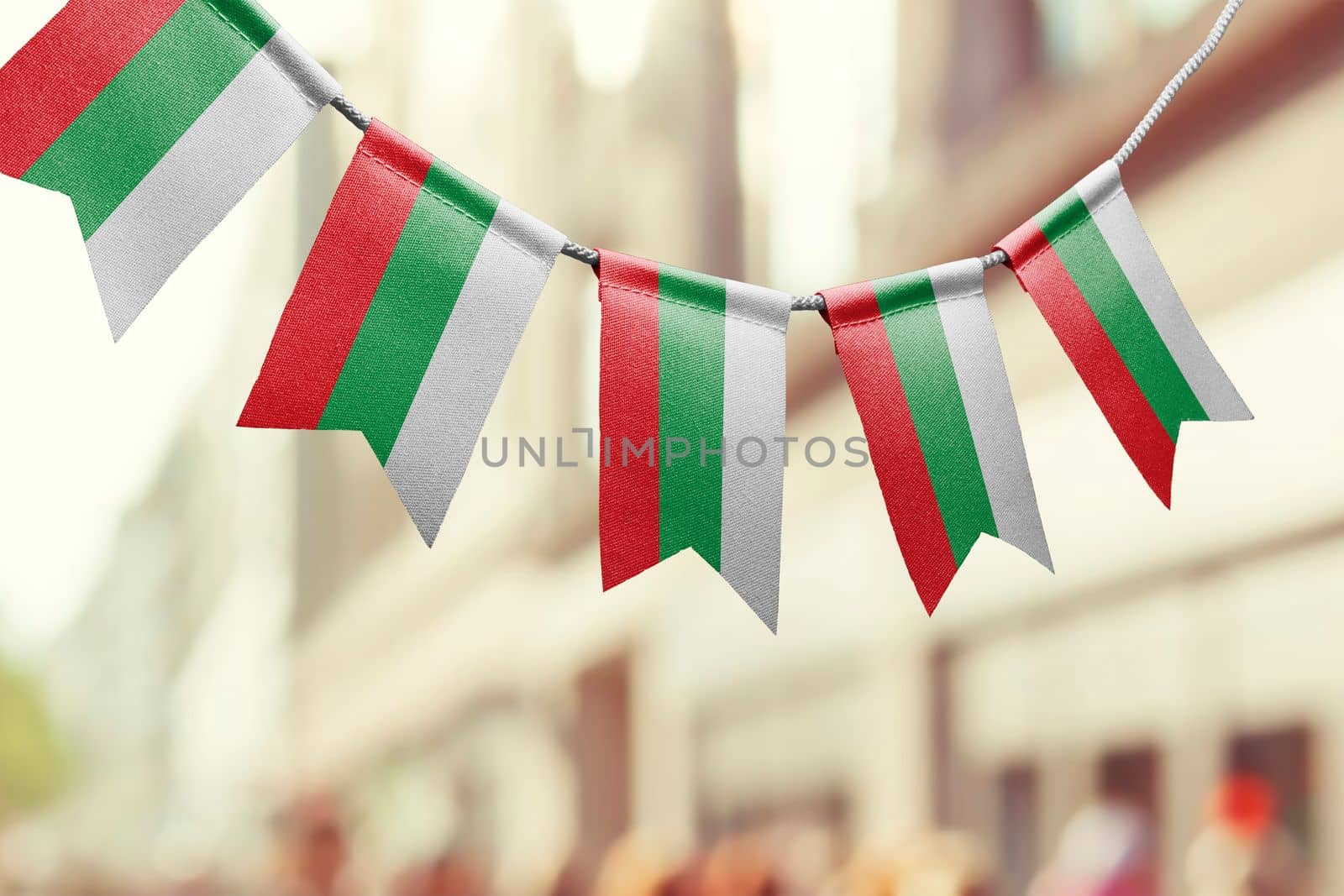 A garland of Bulgaria national flags on an abstract blurred background by butenkow