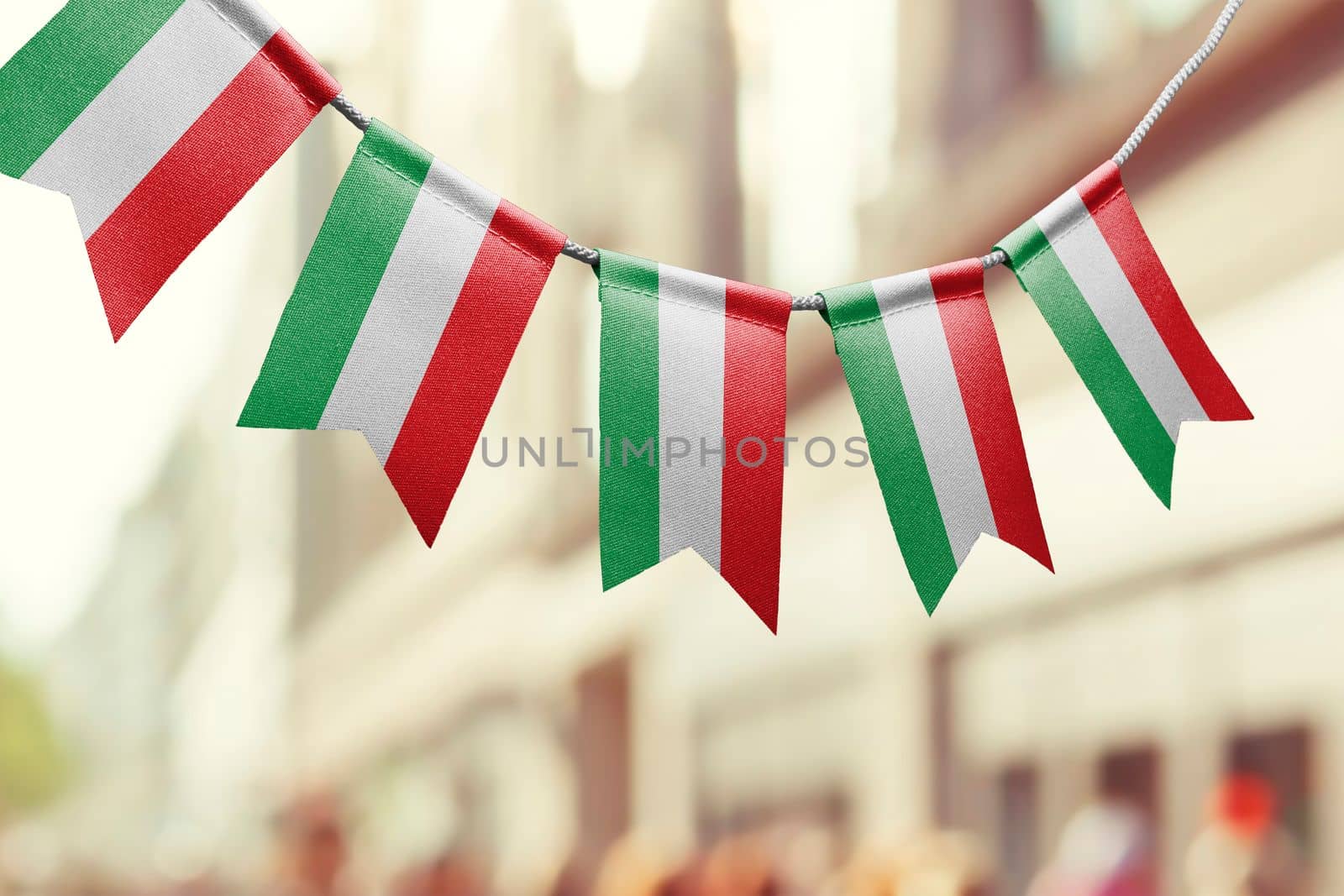 A garland of Hungary national flags on an abstract blurred background by butenkow