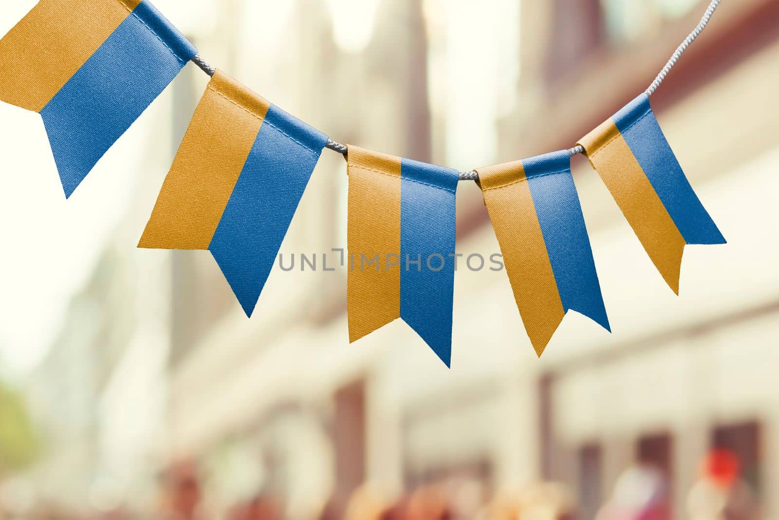A garland of Ukraine national flags on an abstract blurred background.
