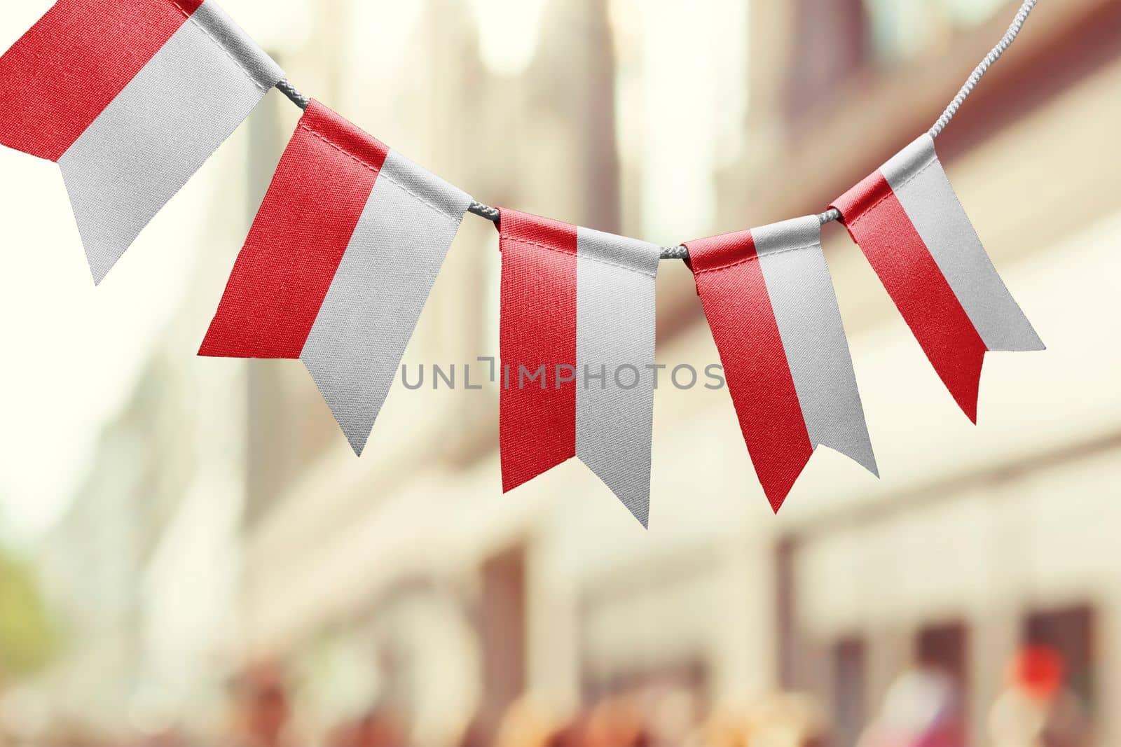 A garland of Poland national flags on an abstract blurred background.